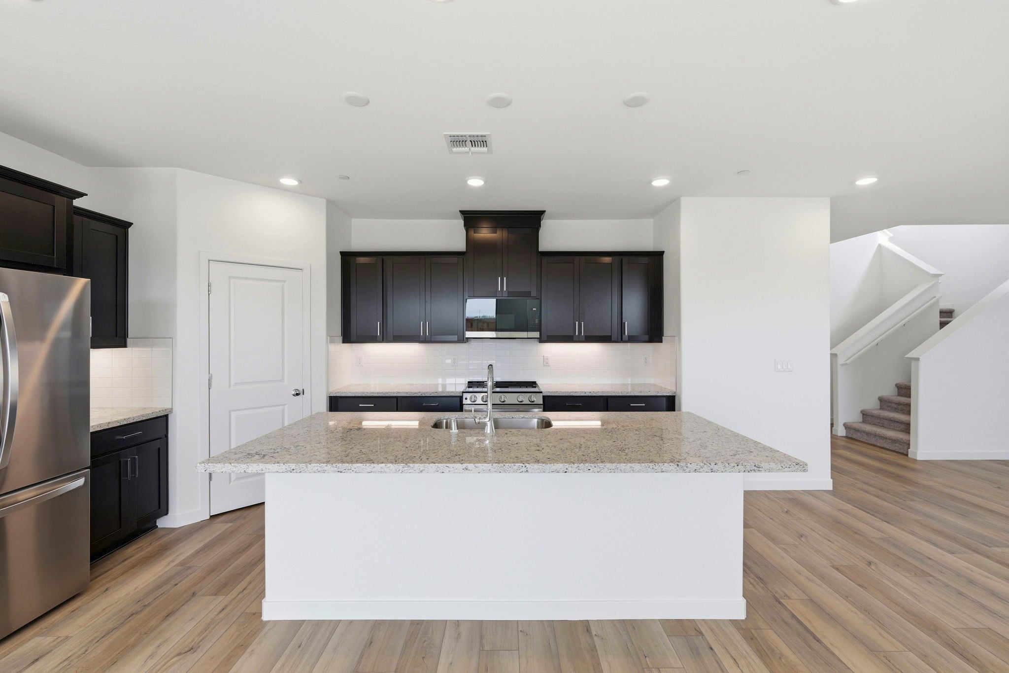 A kitchen with black cabinets.