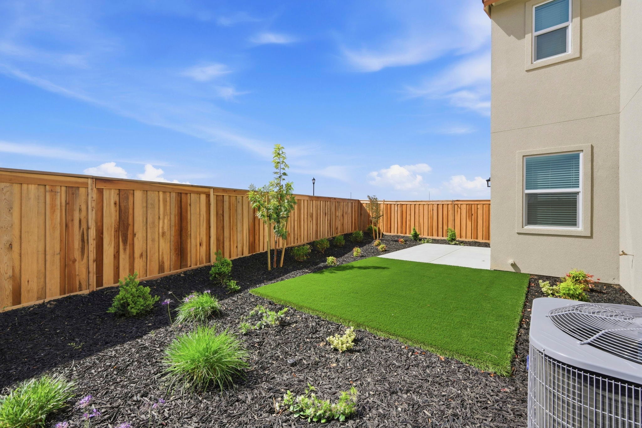 A backyard with a fence and a yard.