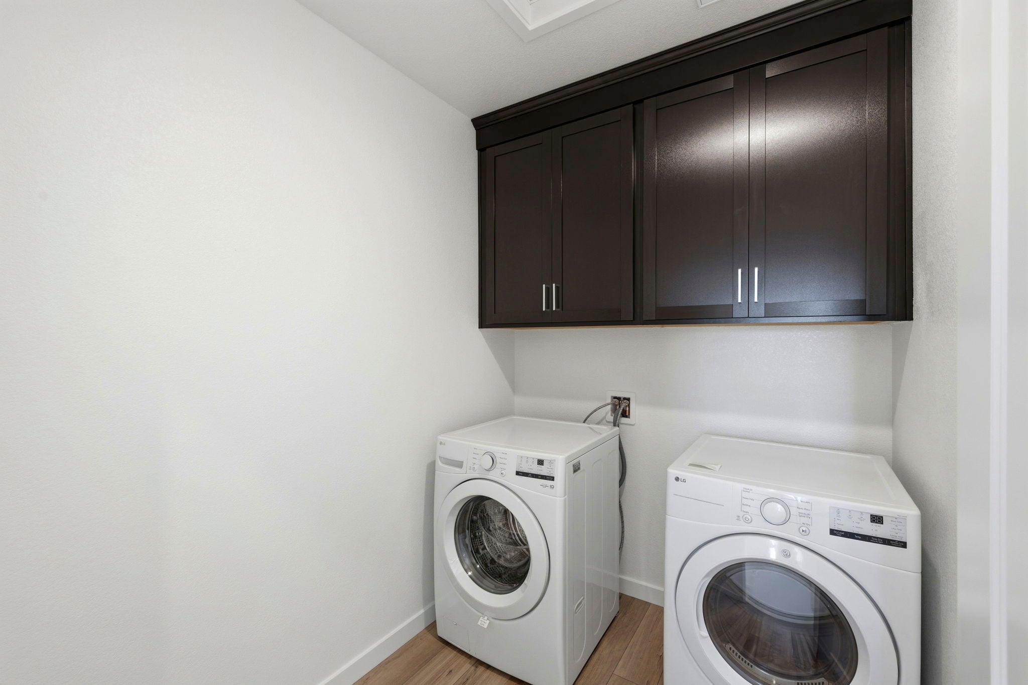 A room with a washing machine and a dryer.