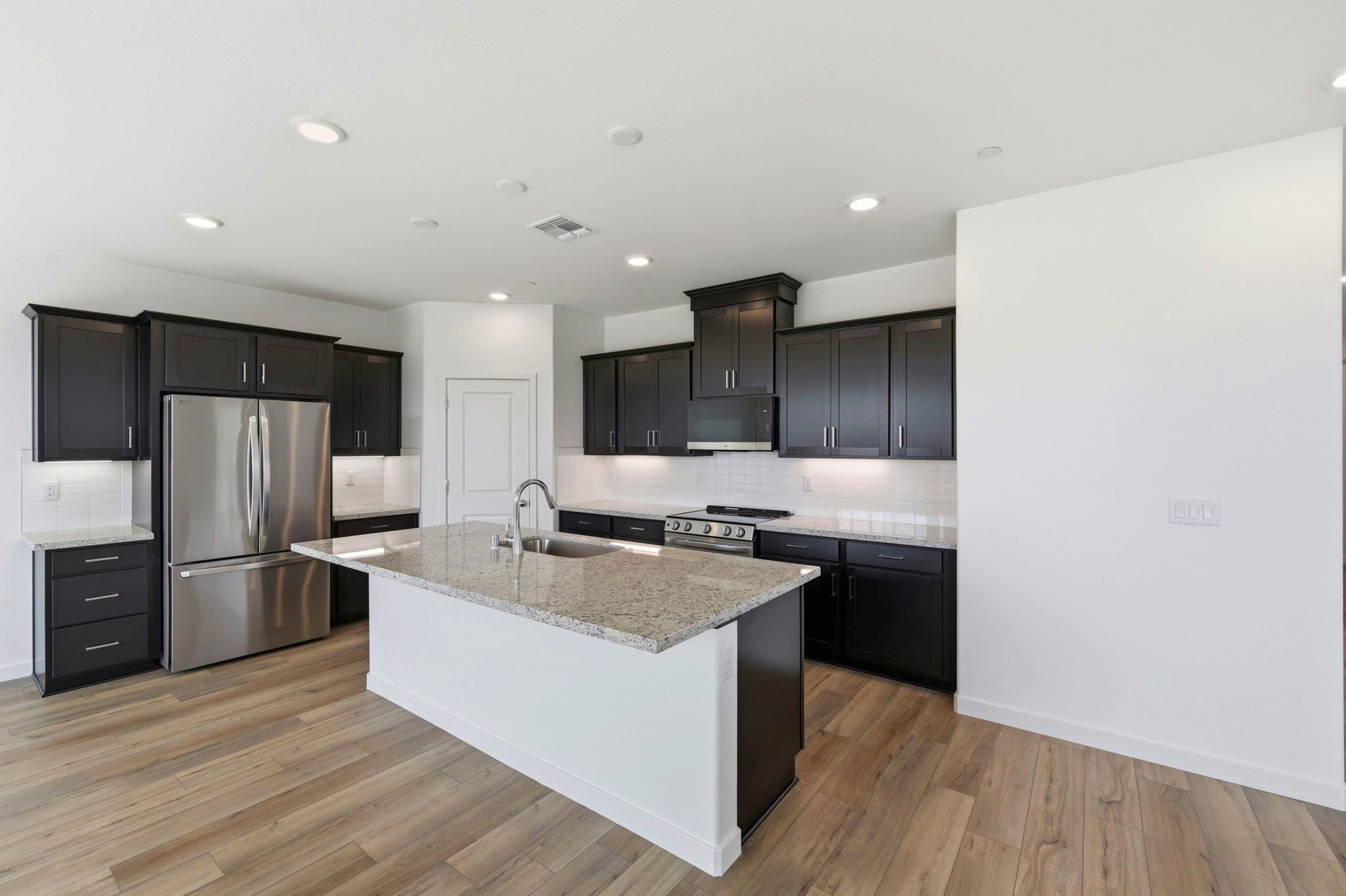 A kitchen with black cabinets.