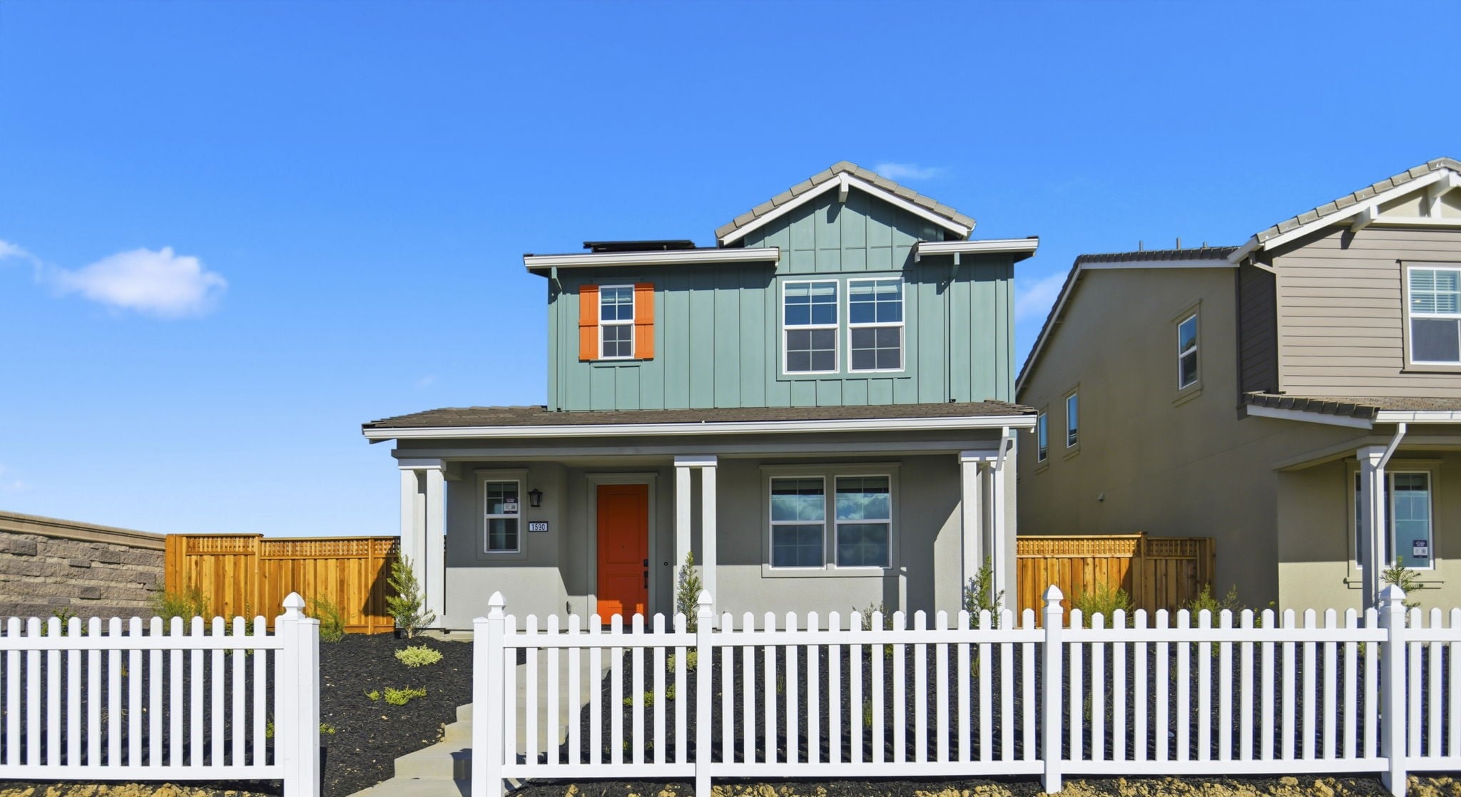 A white picket fence in front of a house.
