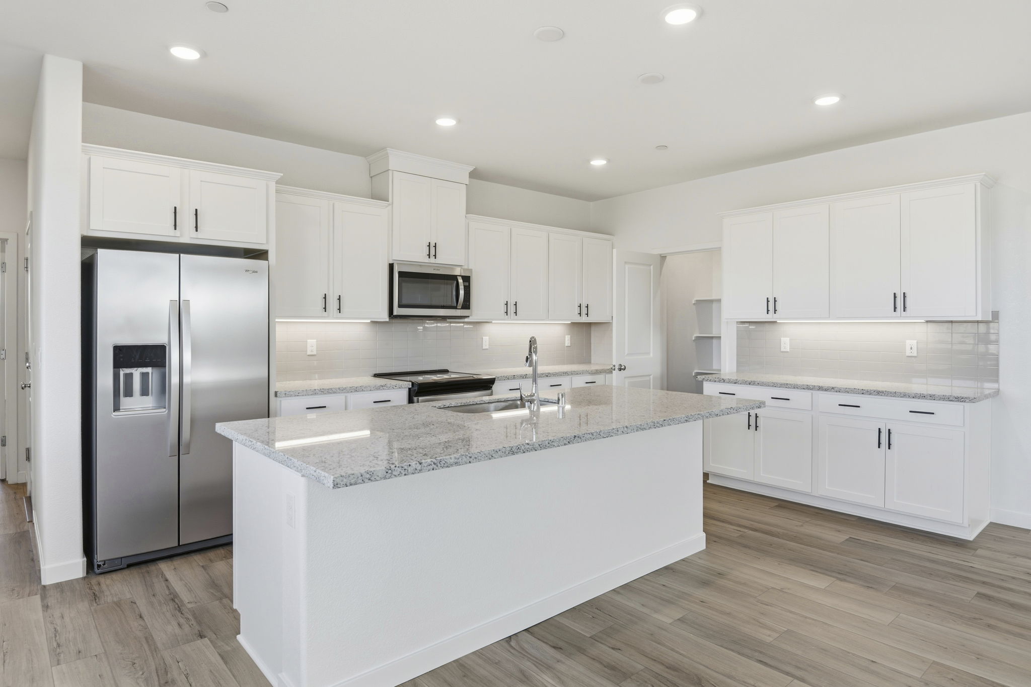 A kitchen with white cabinets.