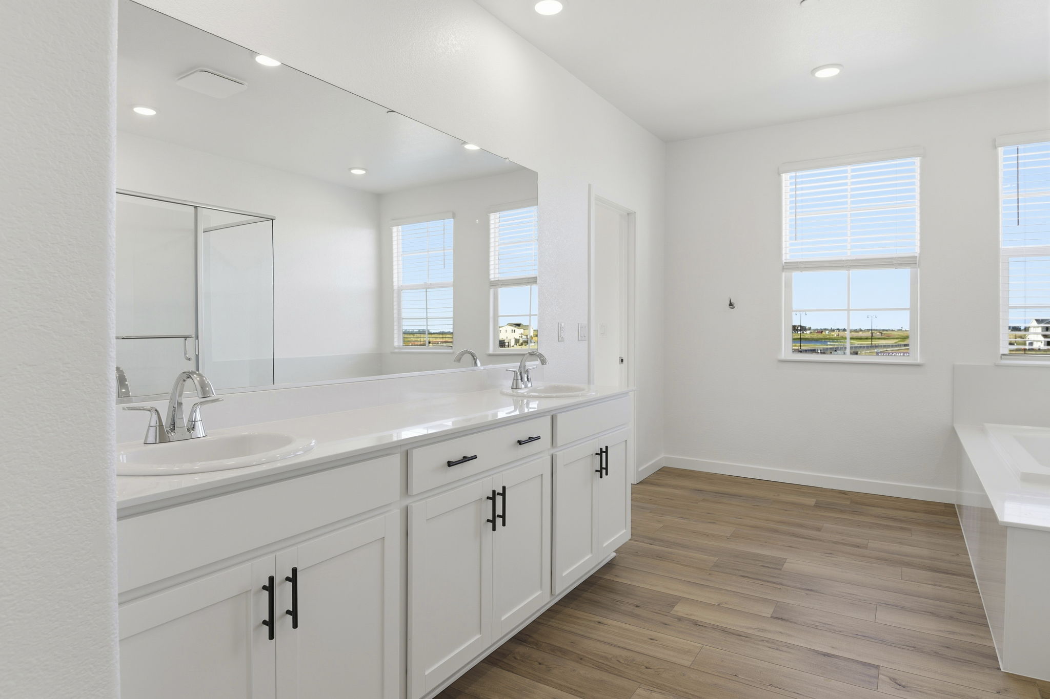 A bathroom with white cabinets.
