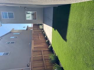 A backyard with a fence and a house.