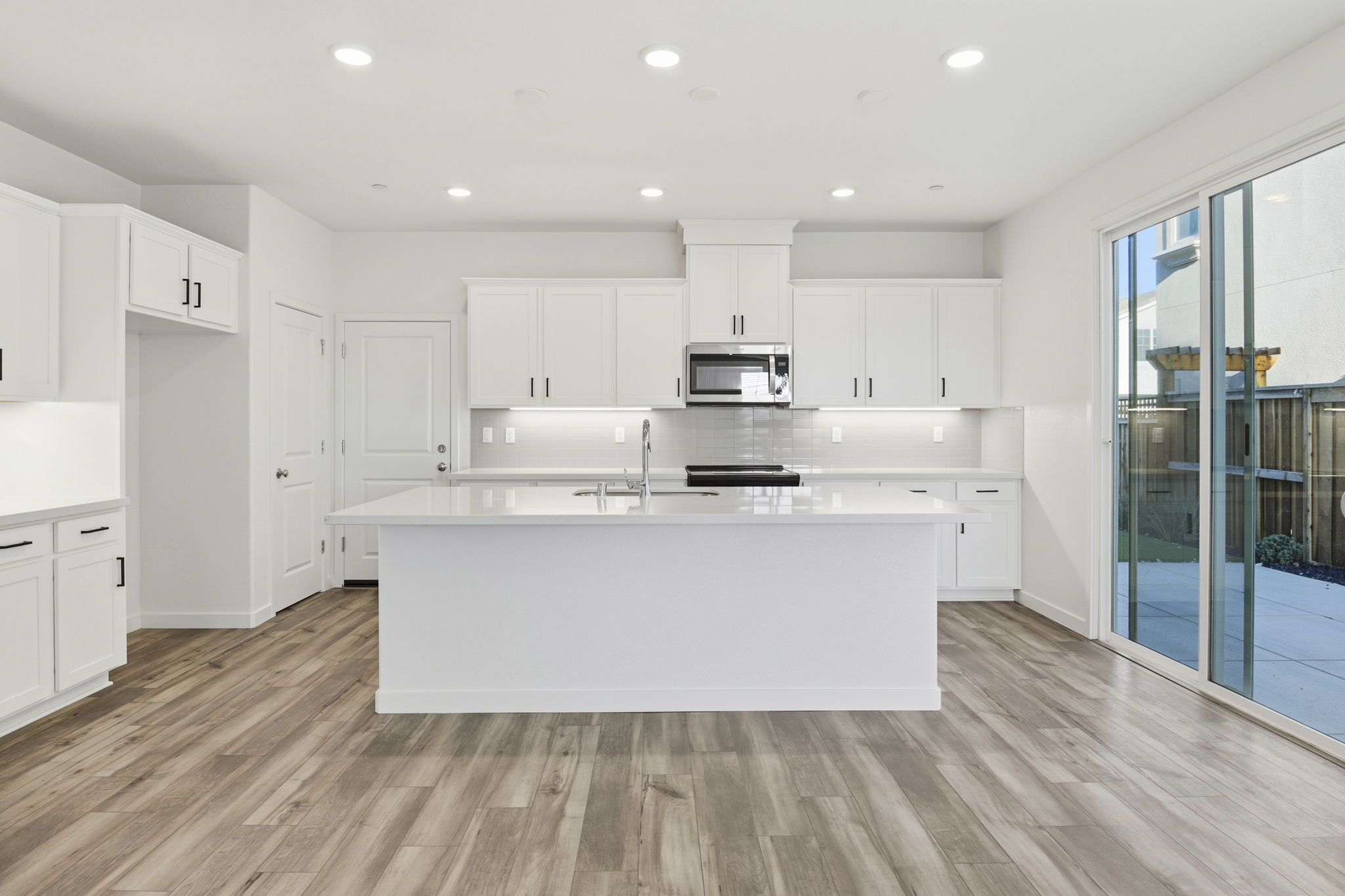 A kitchen with white cabinets.