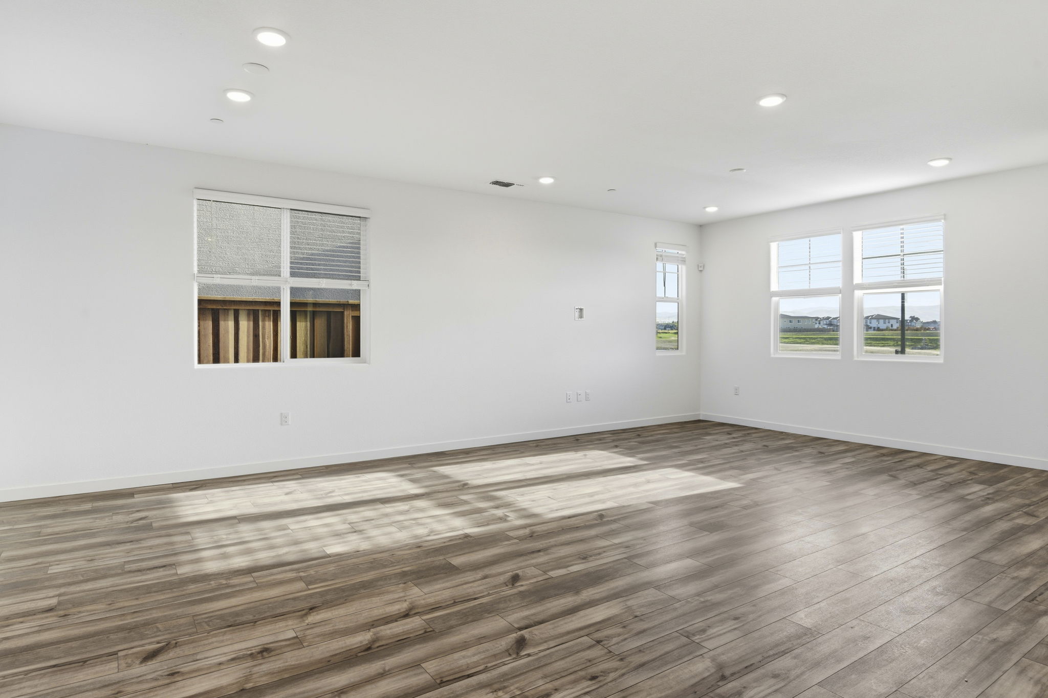 A room with a wood floor and windows.