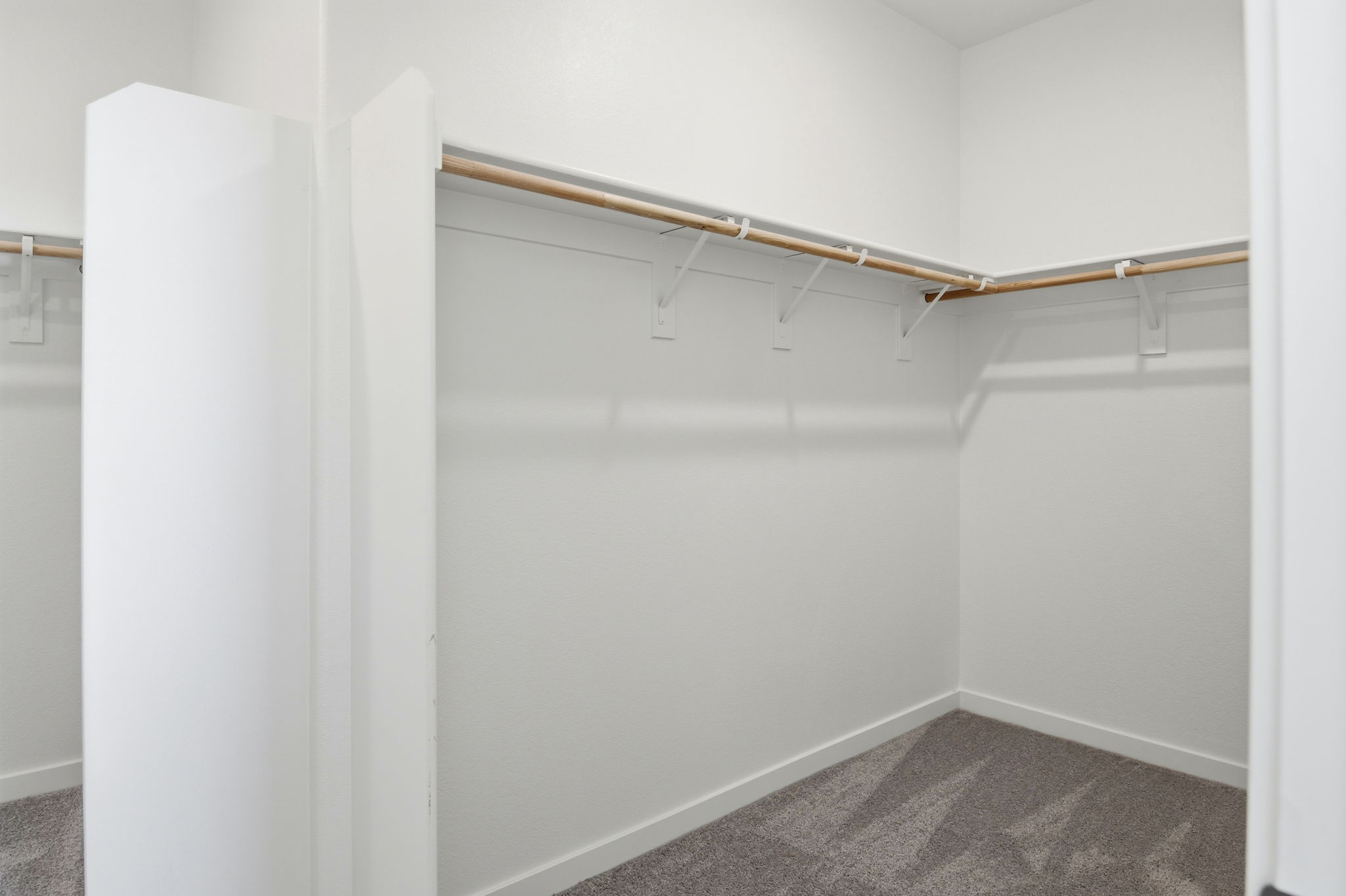 A white wall with a wooden pole.