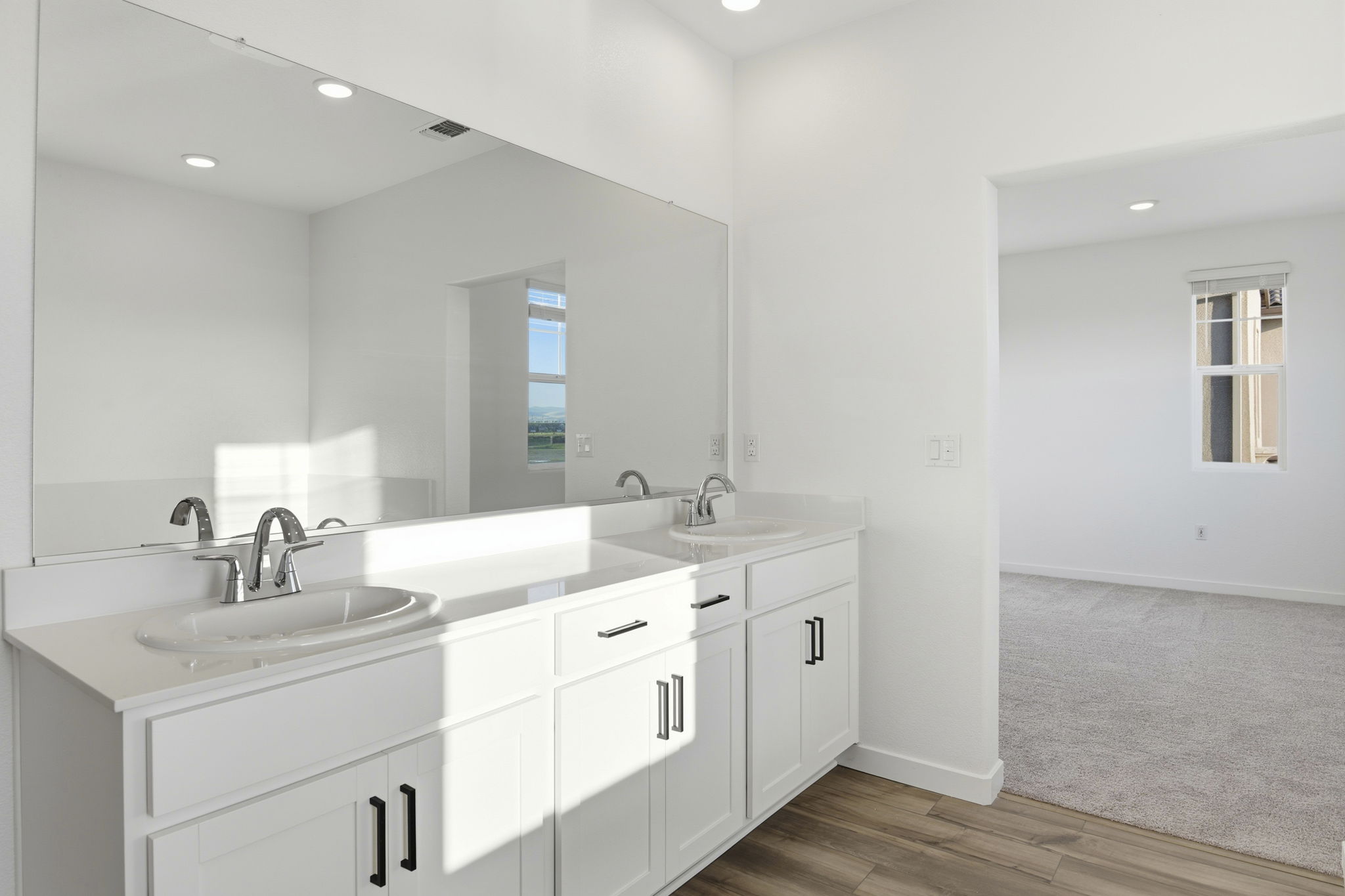 A bathroom with white cabinets.