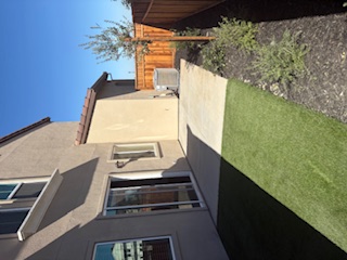 A backyard with a fence and a house.
