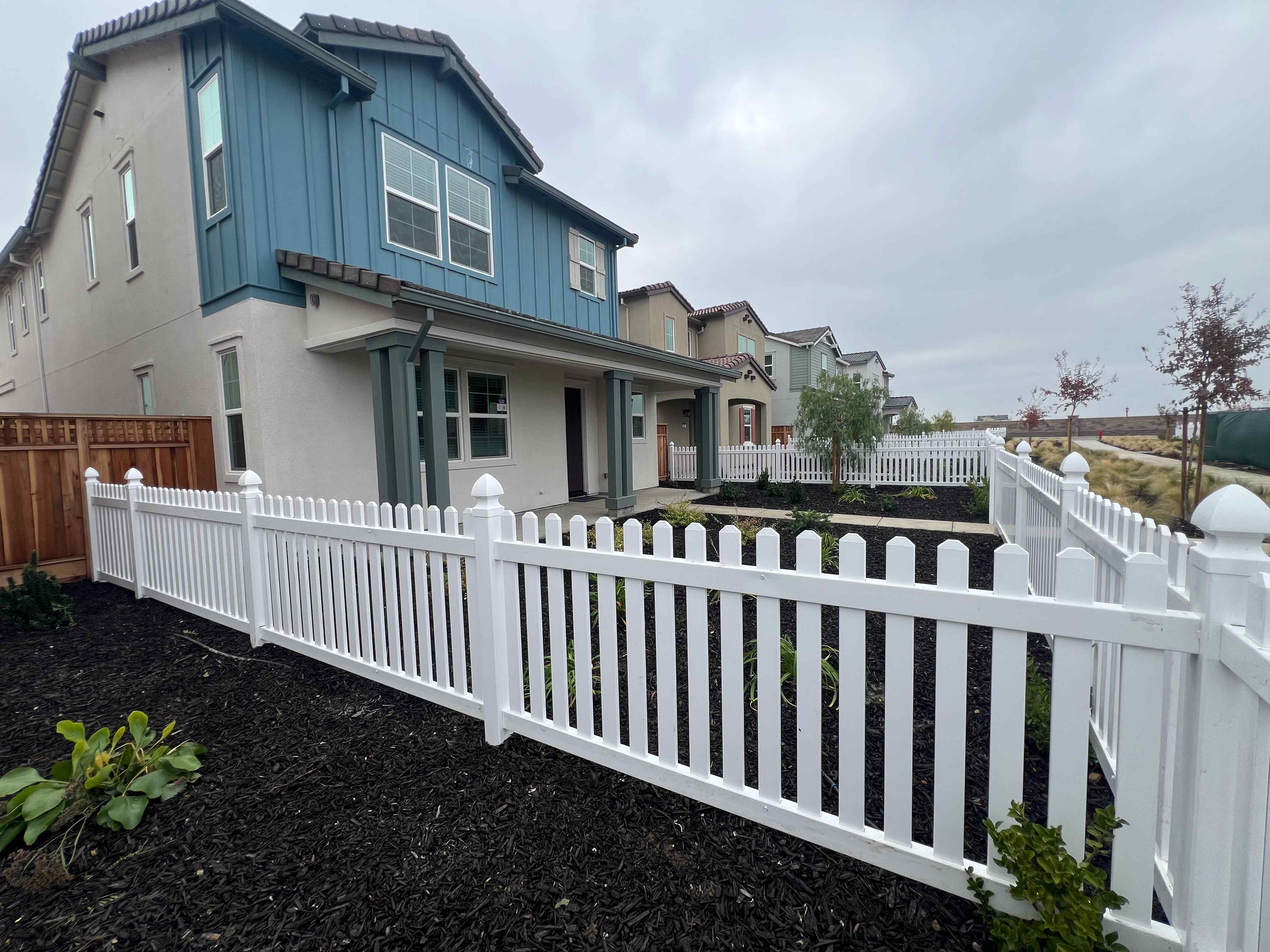 A white picket fence in front of a house.