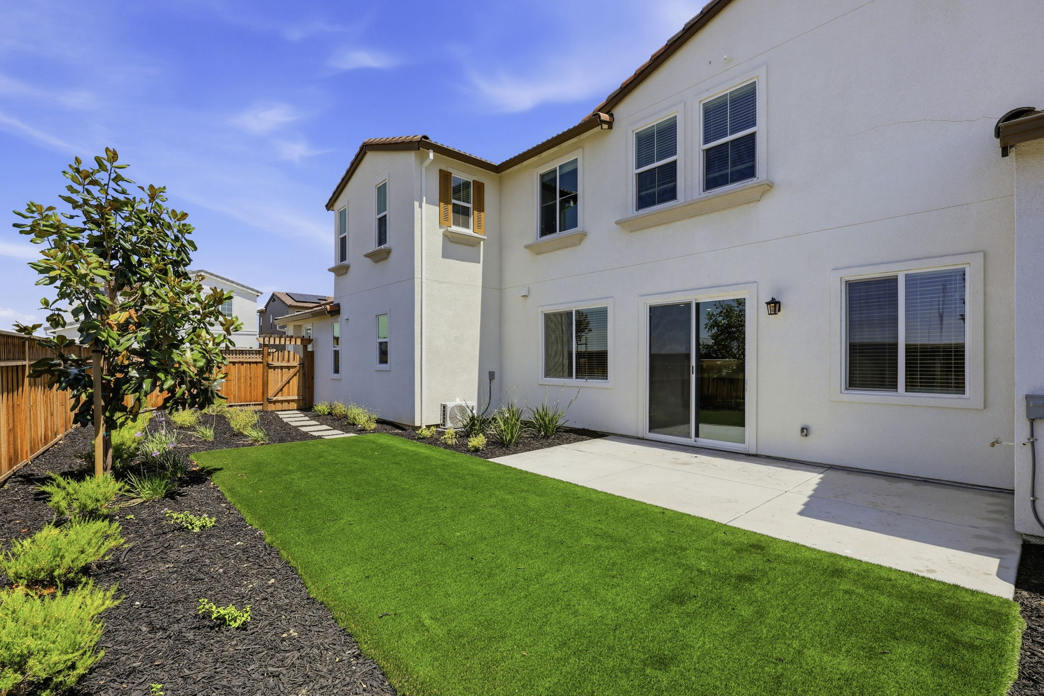 A white house with a green lawn.