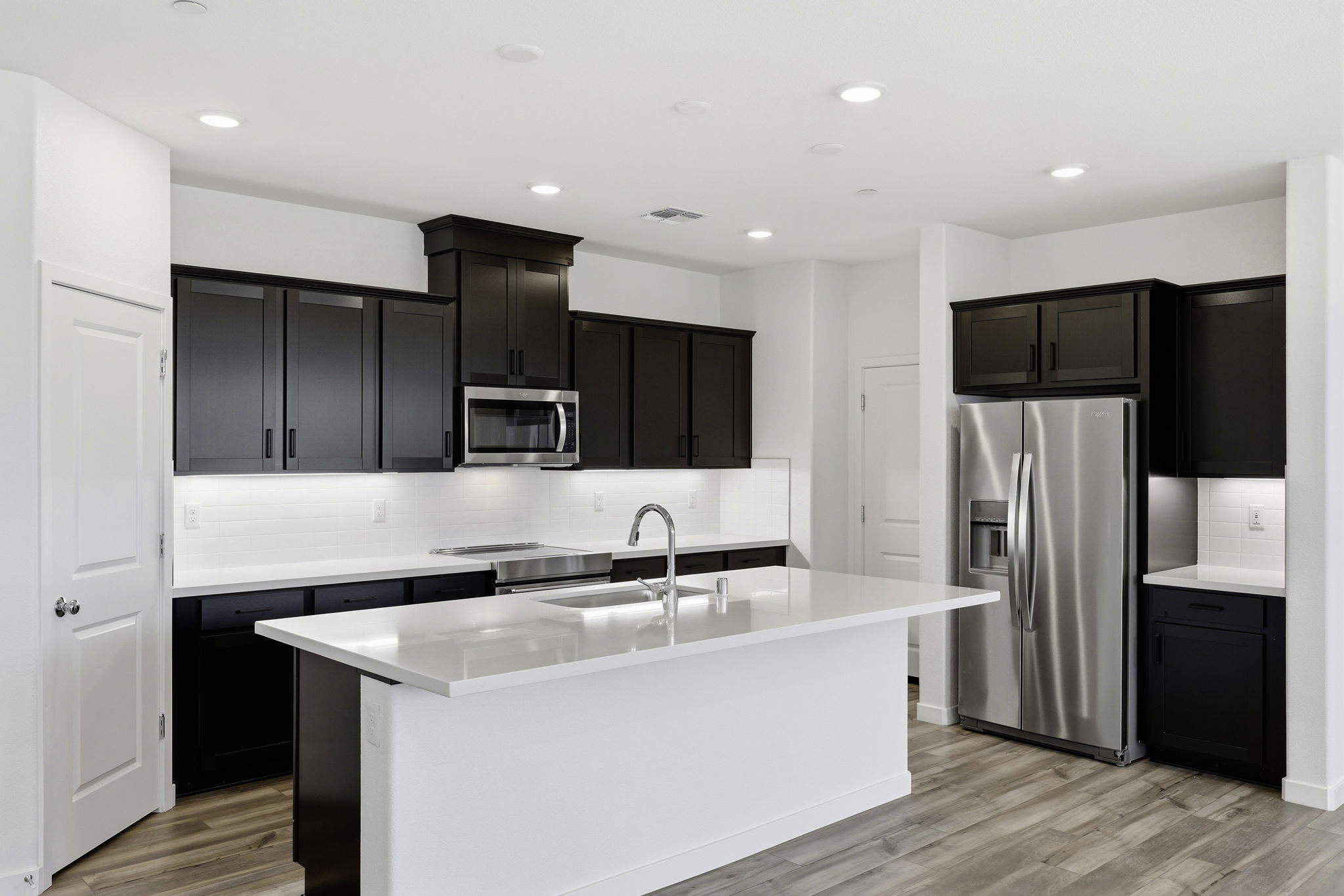 A kitchen with black cabinets.