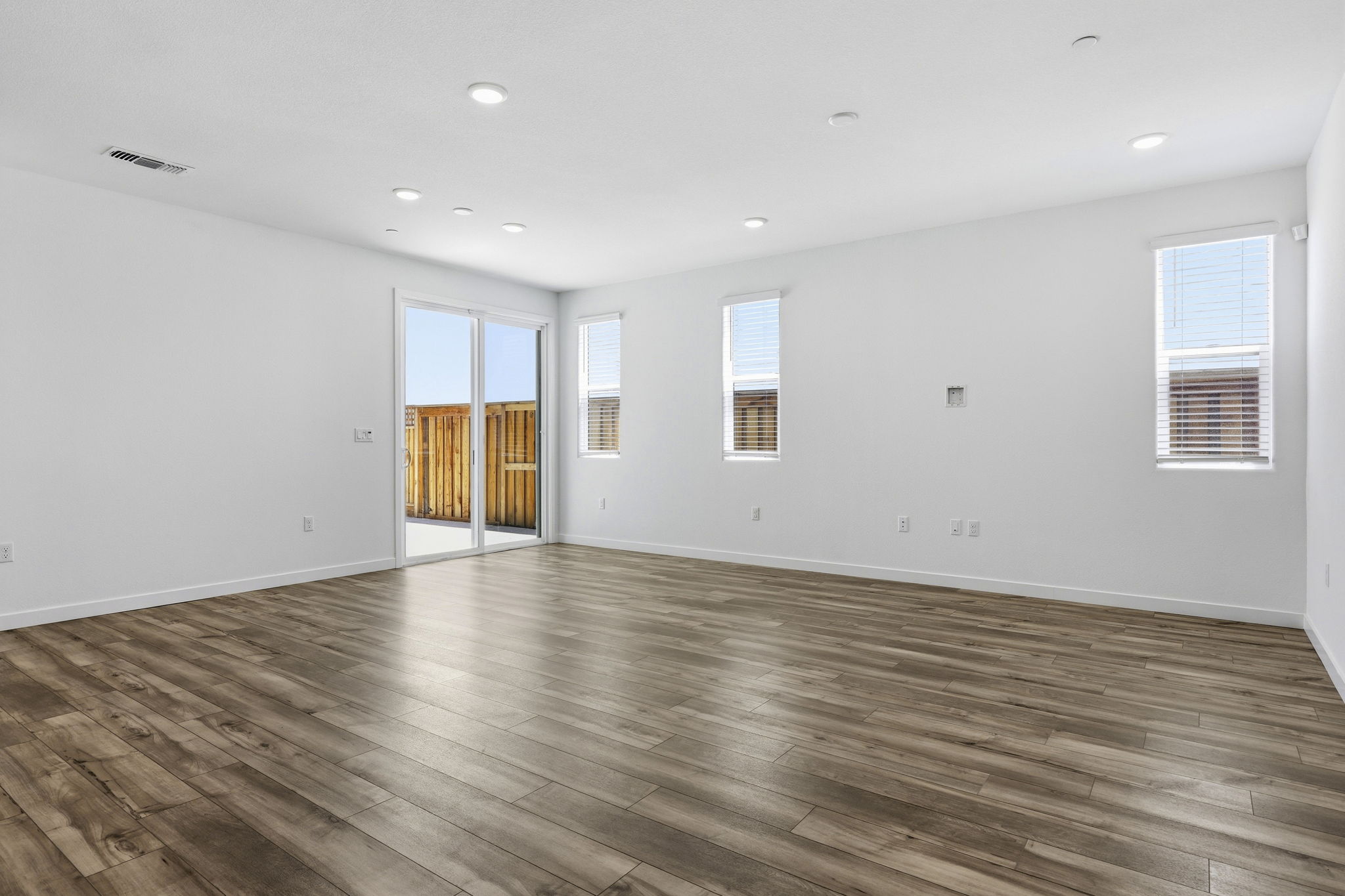 A room with a wood floor and windows.