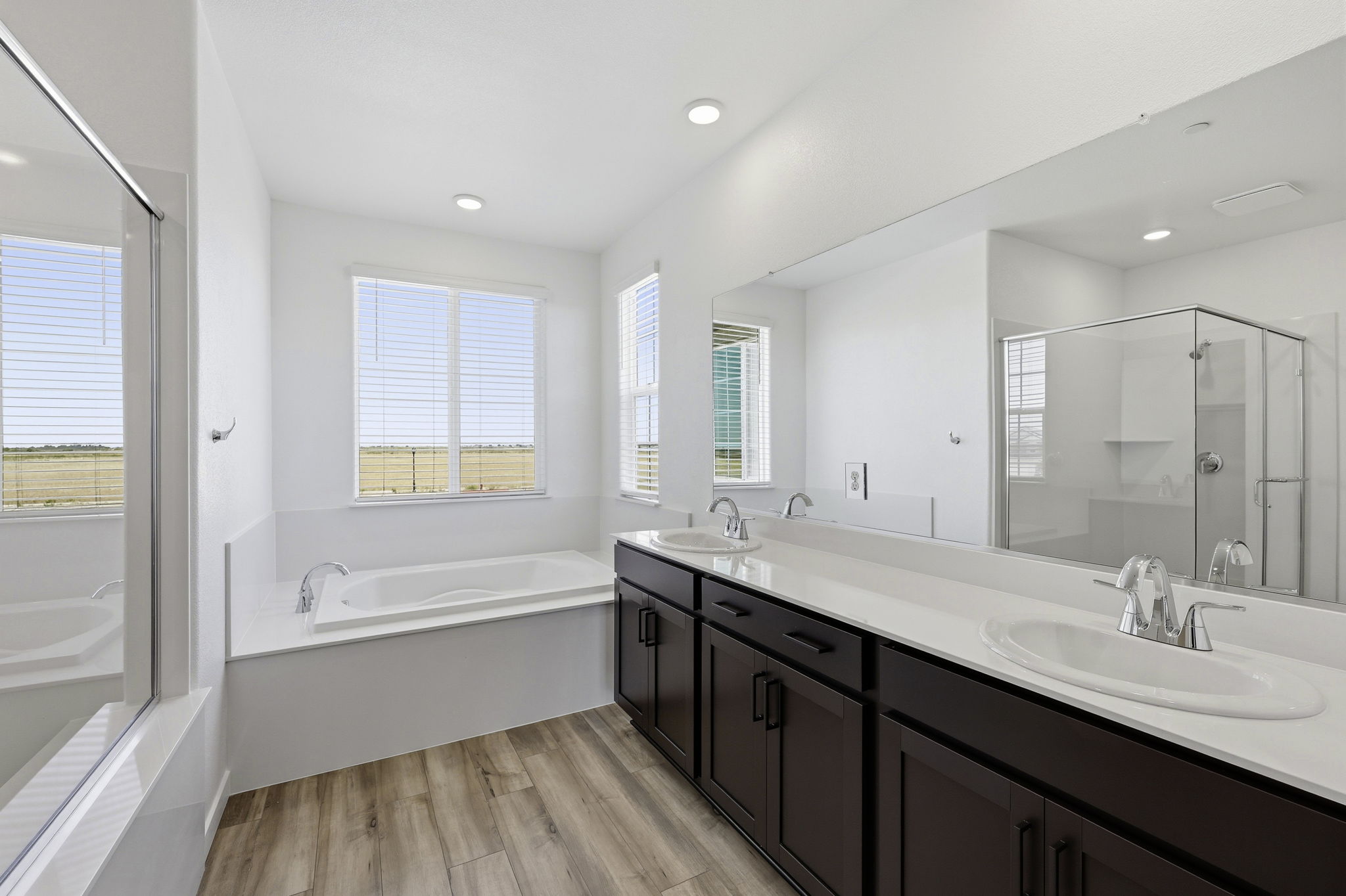 A bathroom with a tub sink and a mirror.