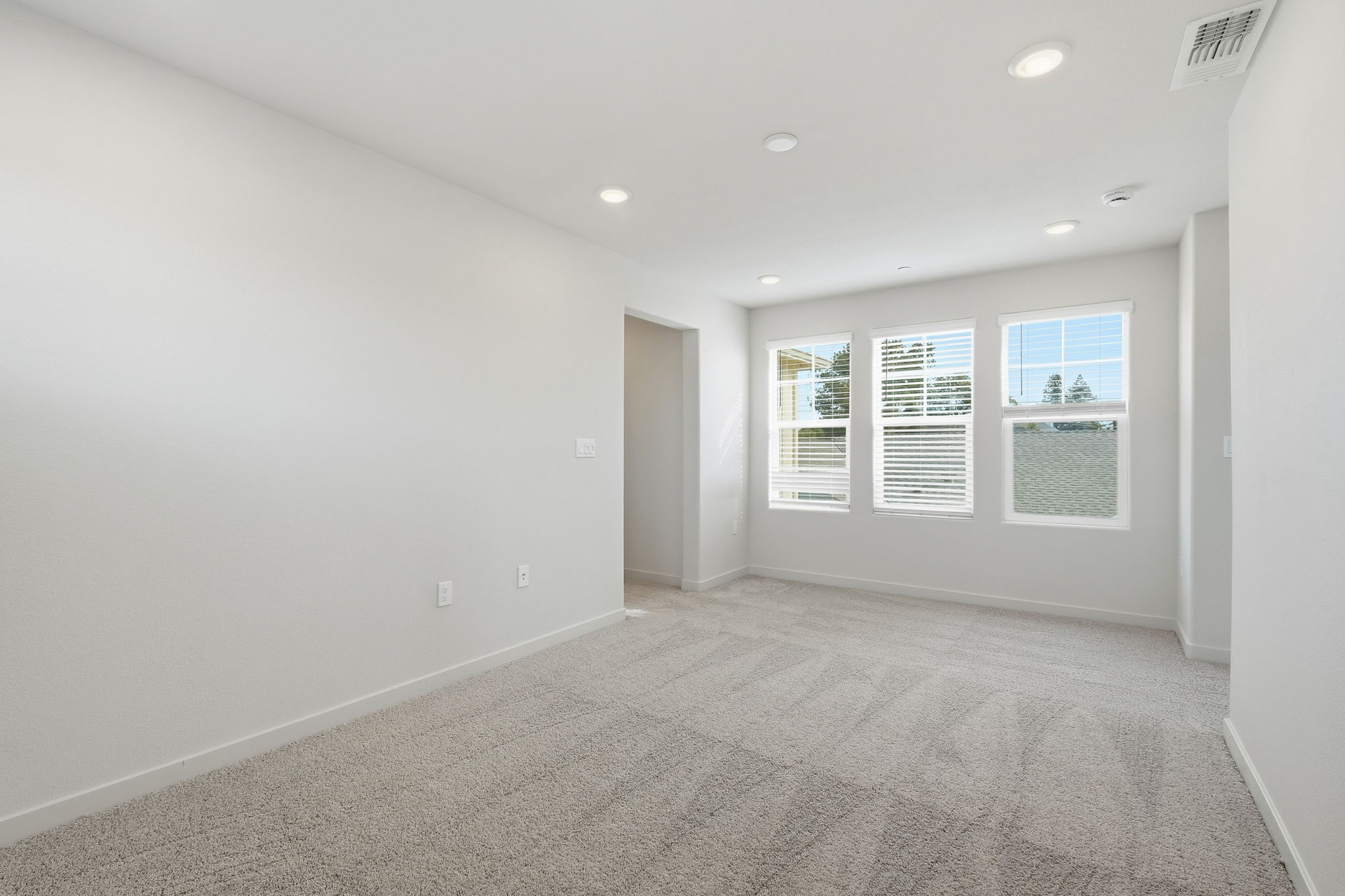 A room with a carpet and a door.
