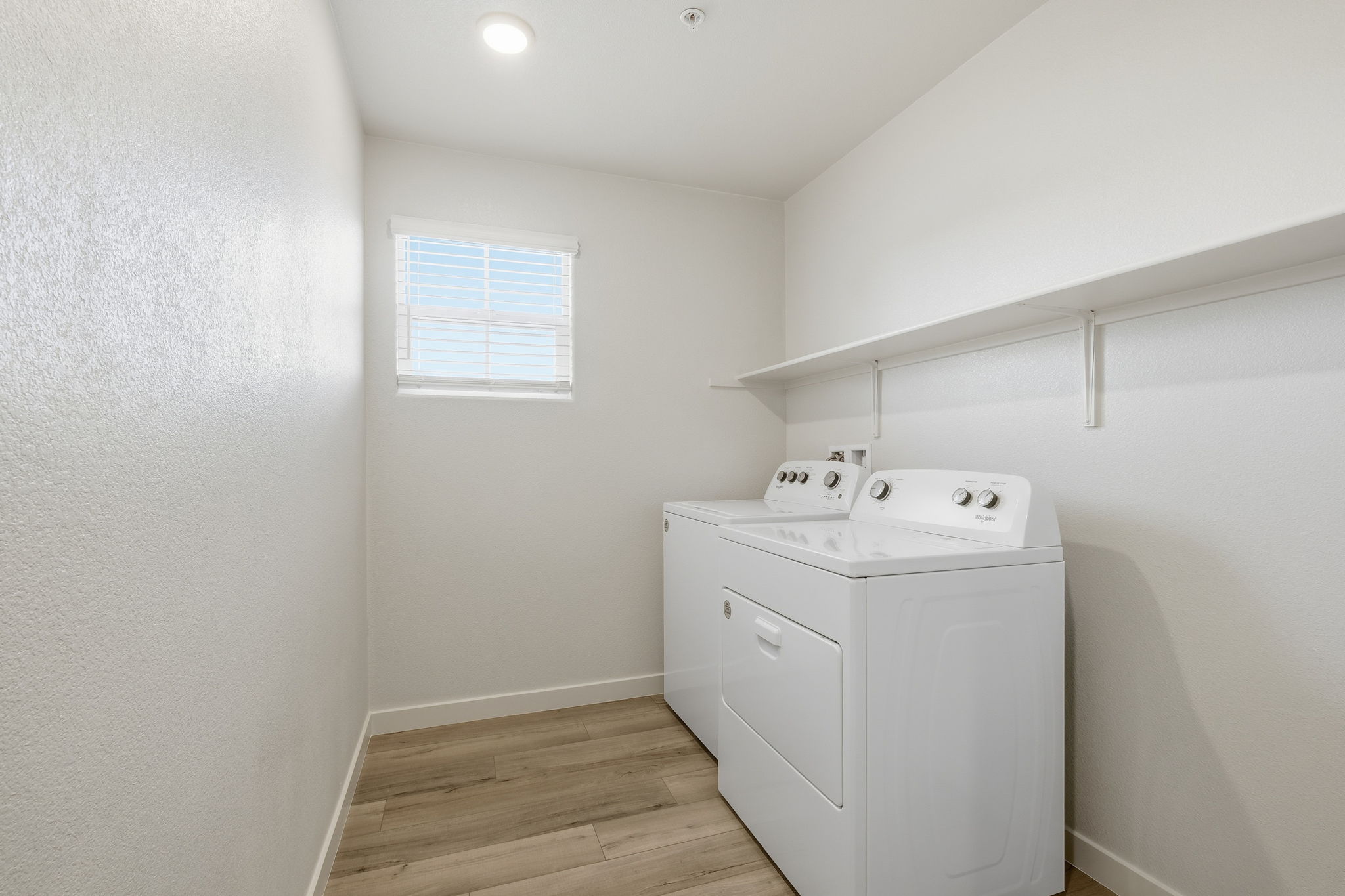 A white room with a sink and a white cabinet.