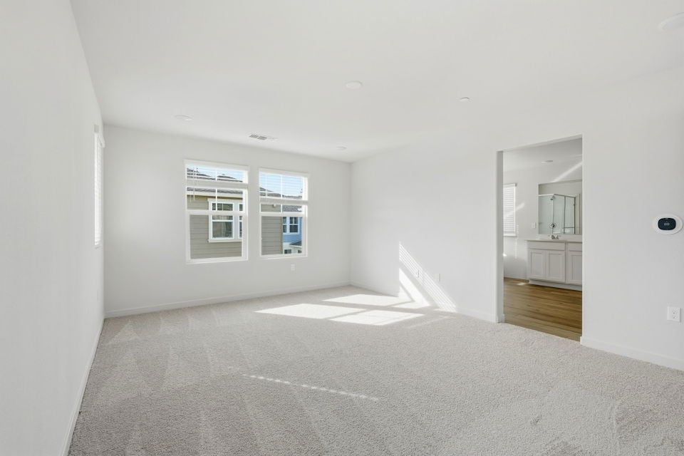 A large empty room with a staircase.