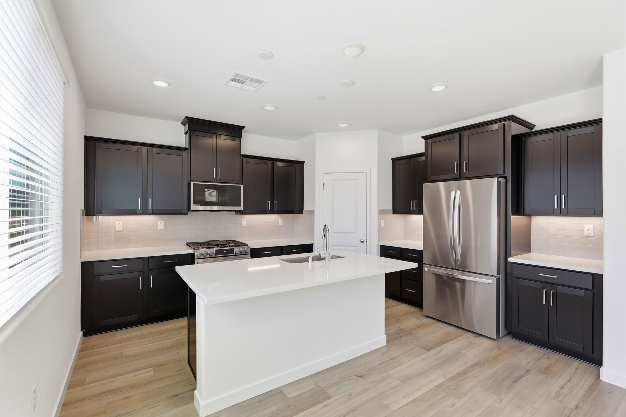 A kitchen with black cabinets.