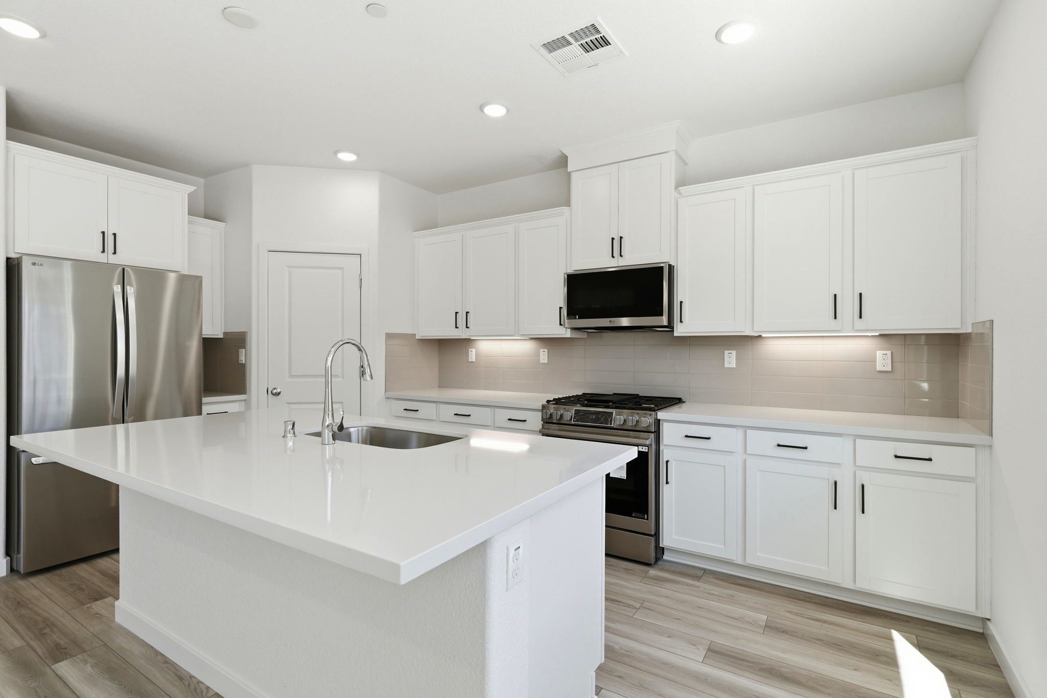 A kitchen with white cabinets.