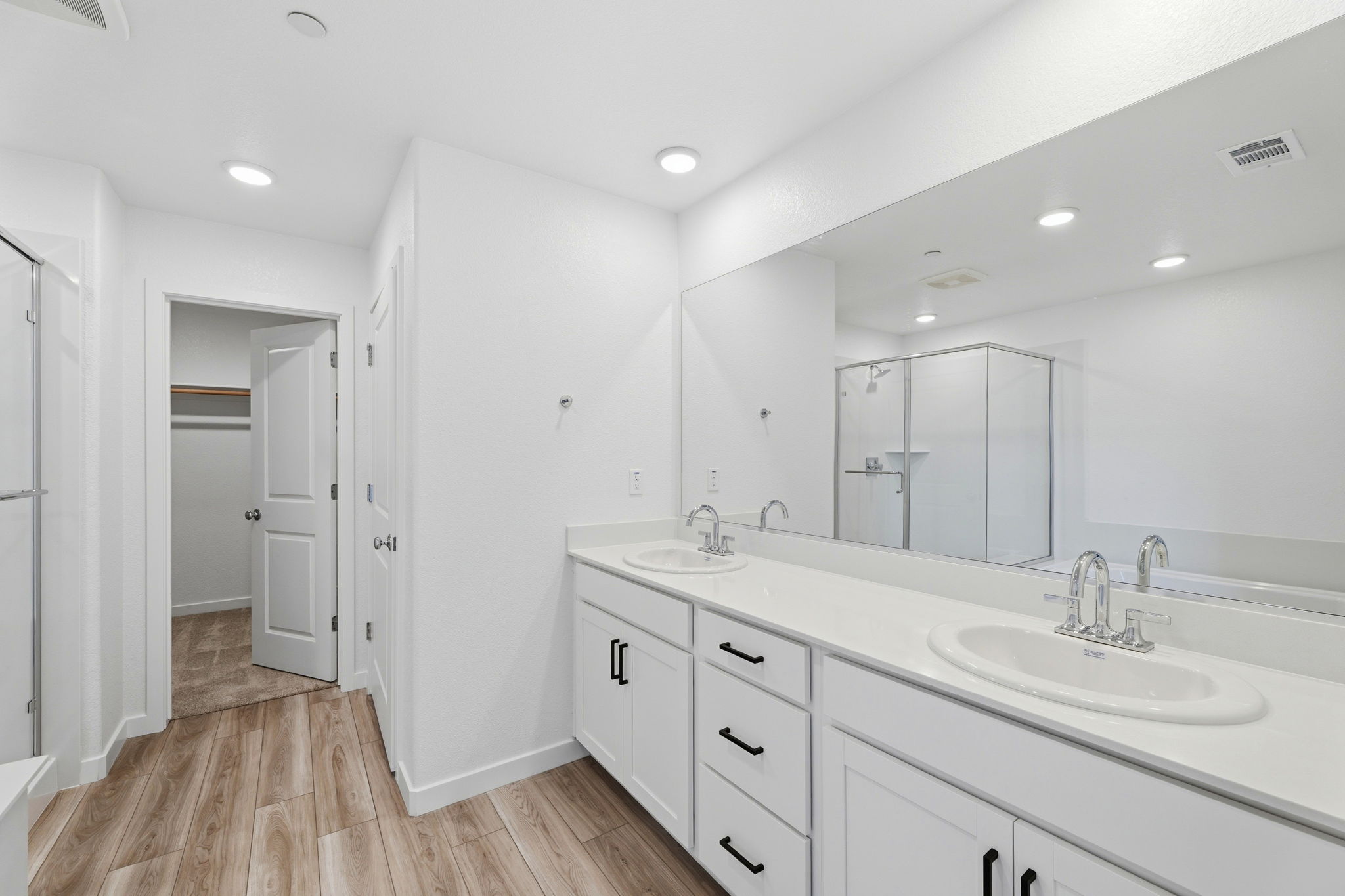 A bathroom with white cabinets.