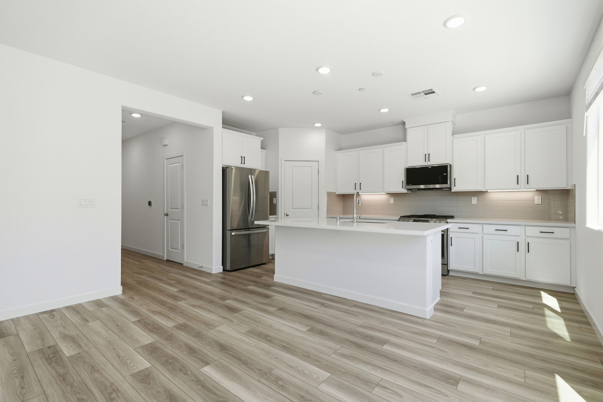 A kitchen with white cabinets.