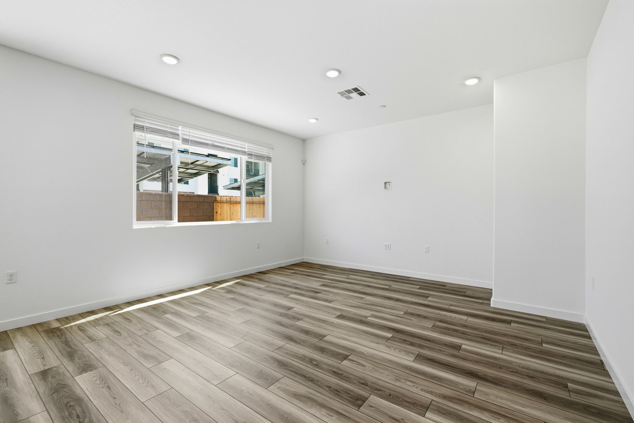 A room with a wood floor and a window.