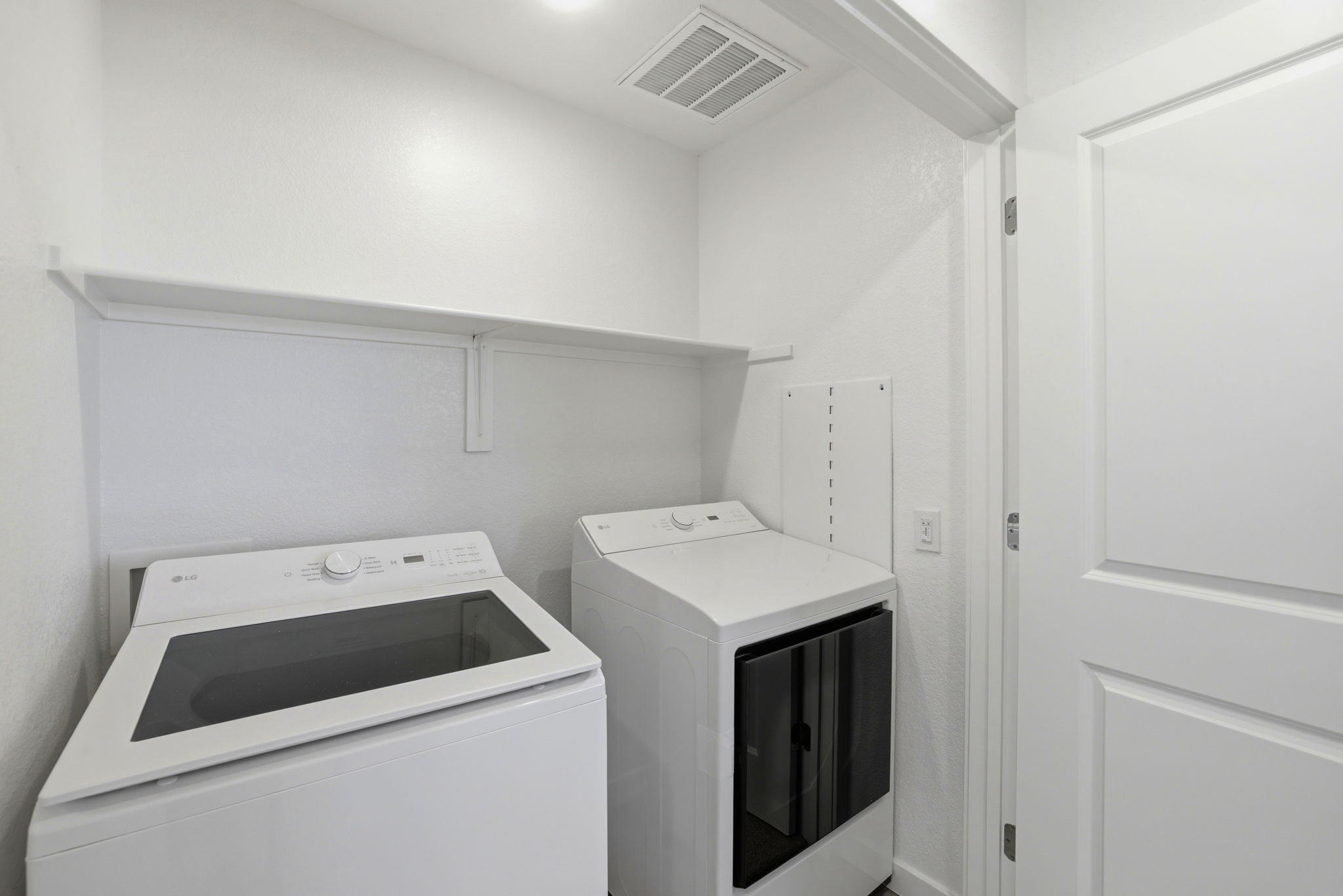 A white laundry room with a washer and dryer.