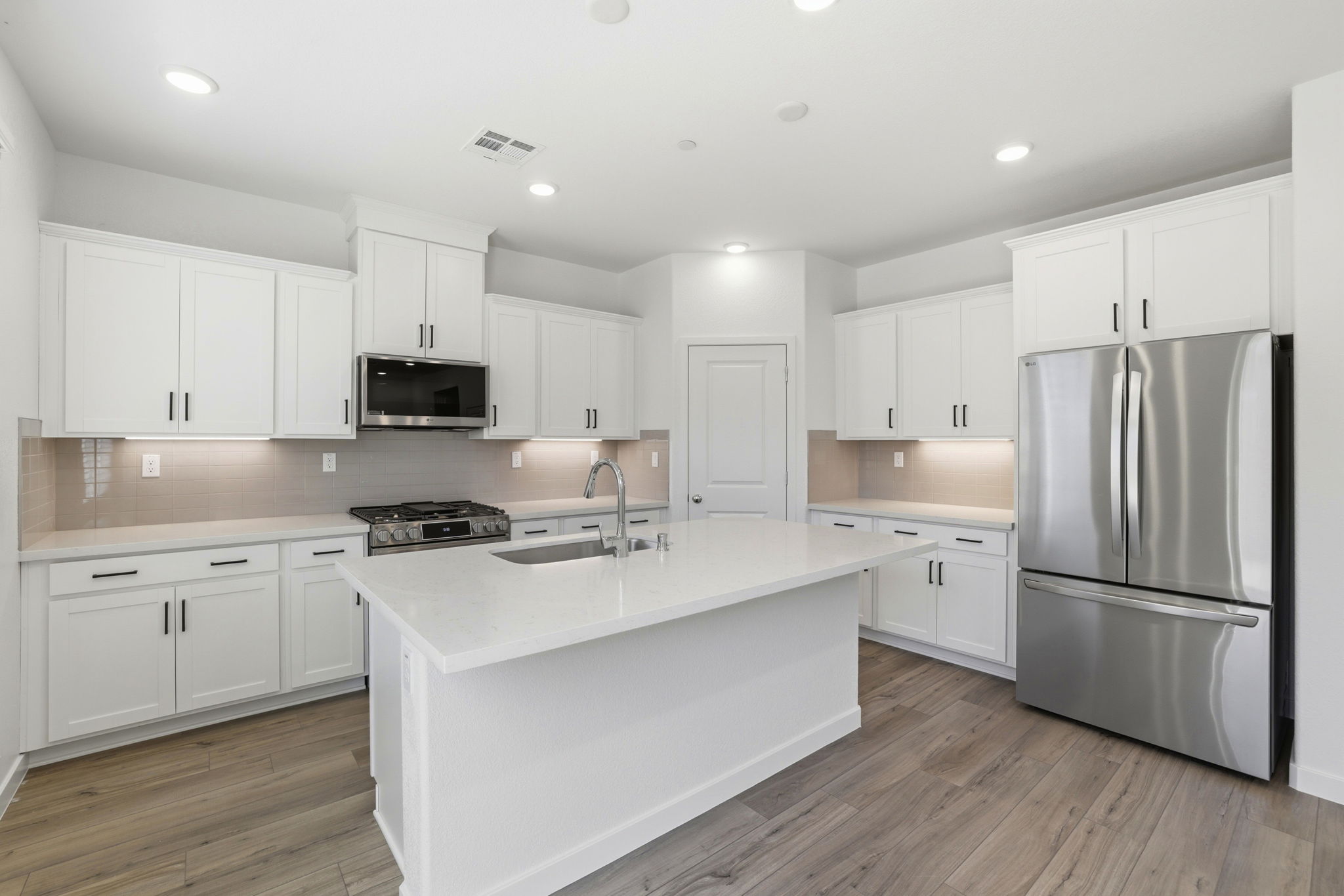 A kitchen with white cabinets.