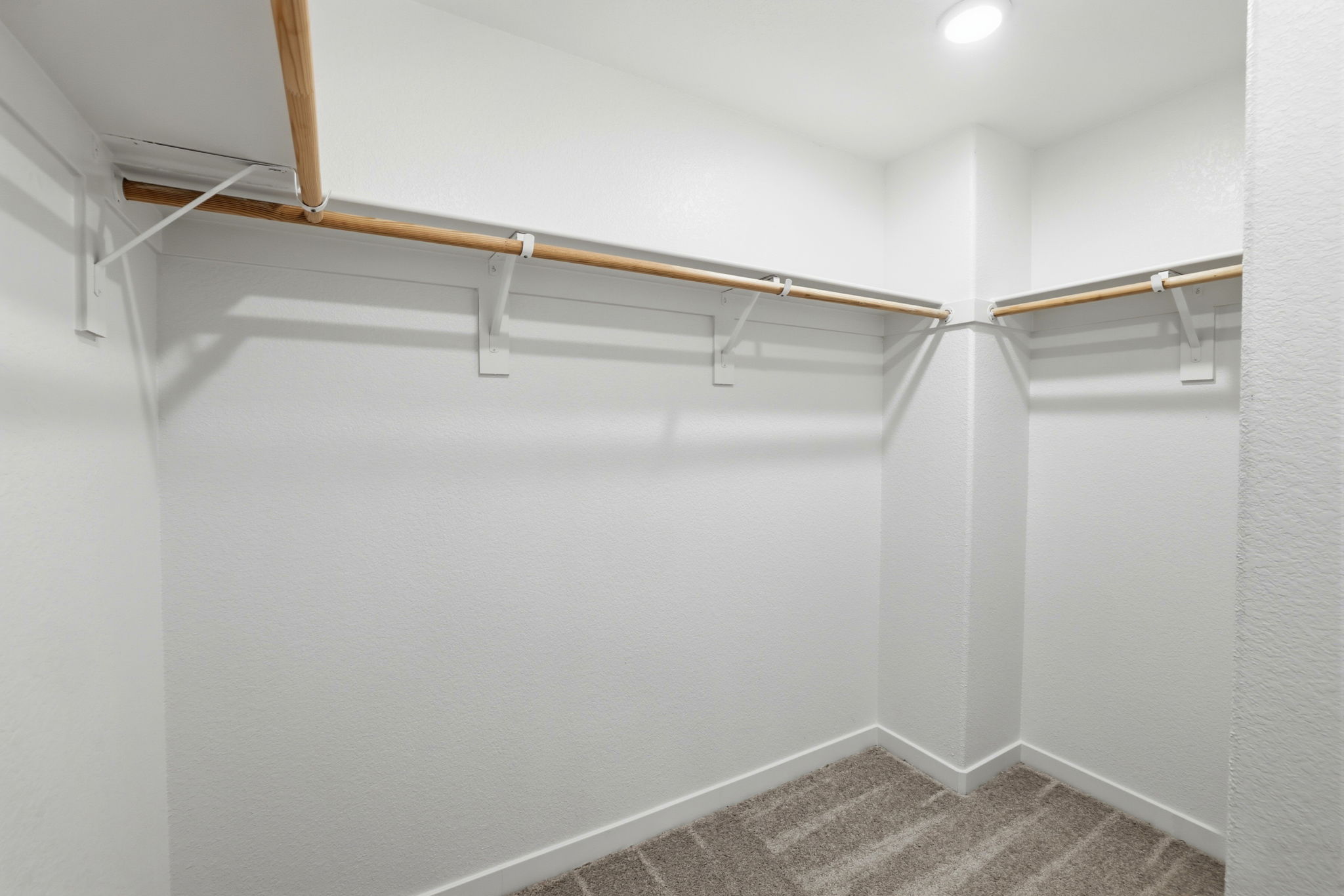 A white wall with a metal bar.