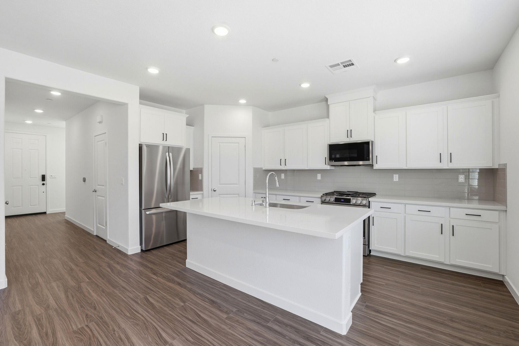 A kitchen with white cabinets.