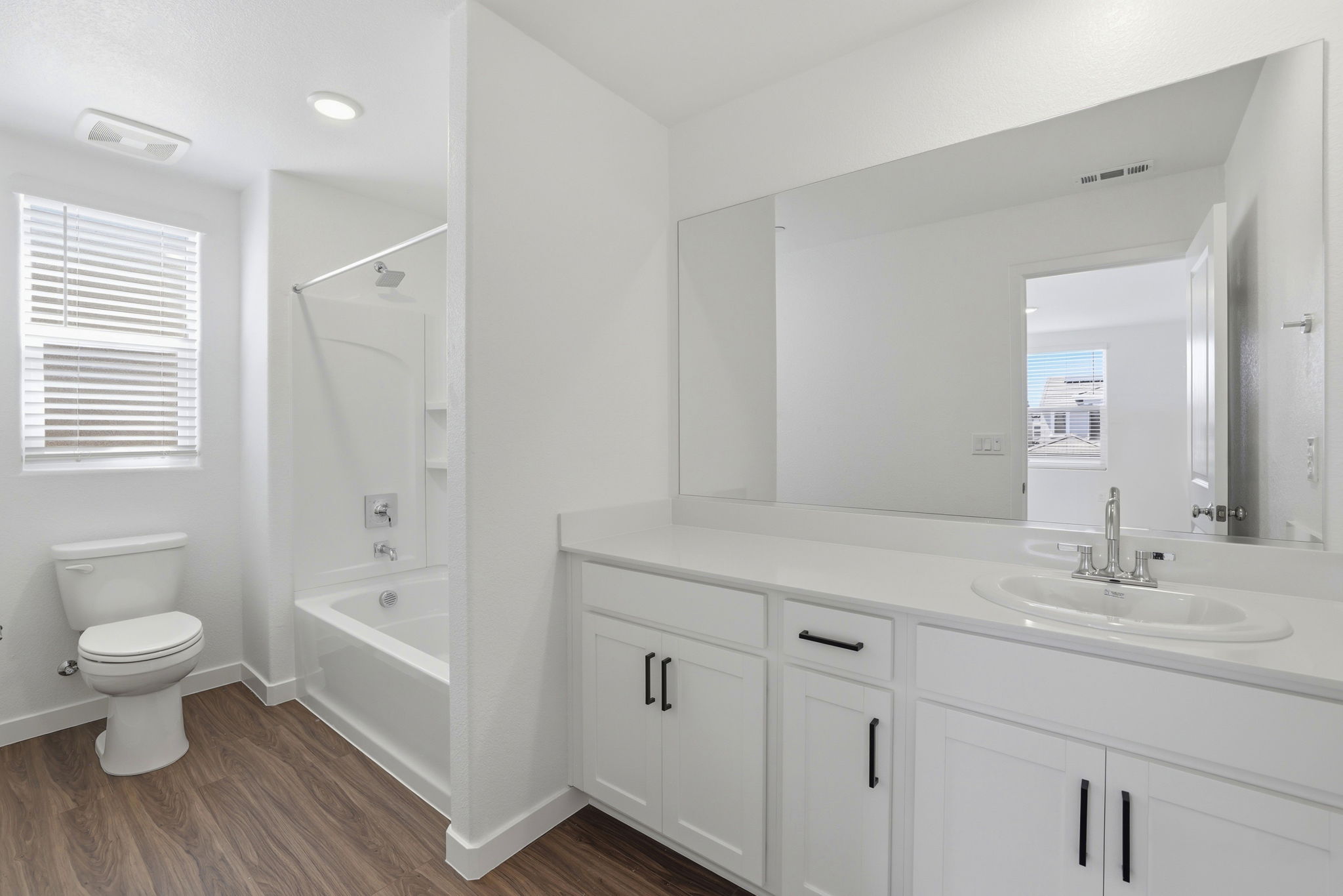A bathroom with a large mirror.