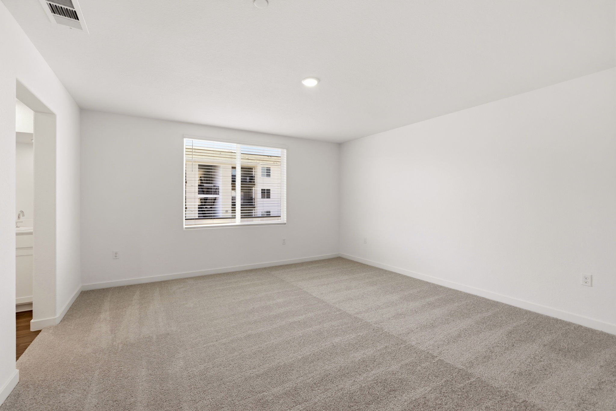 A room with a window and a carpet.