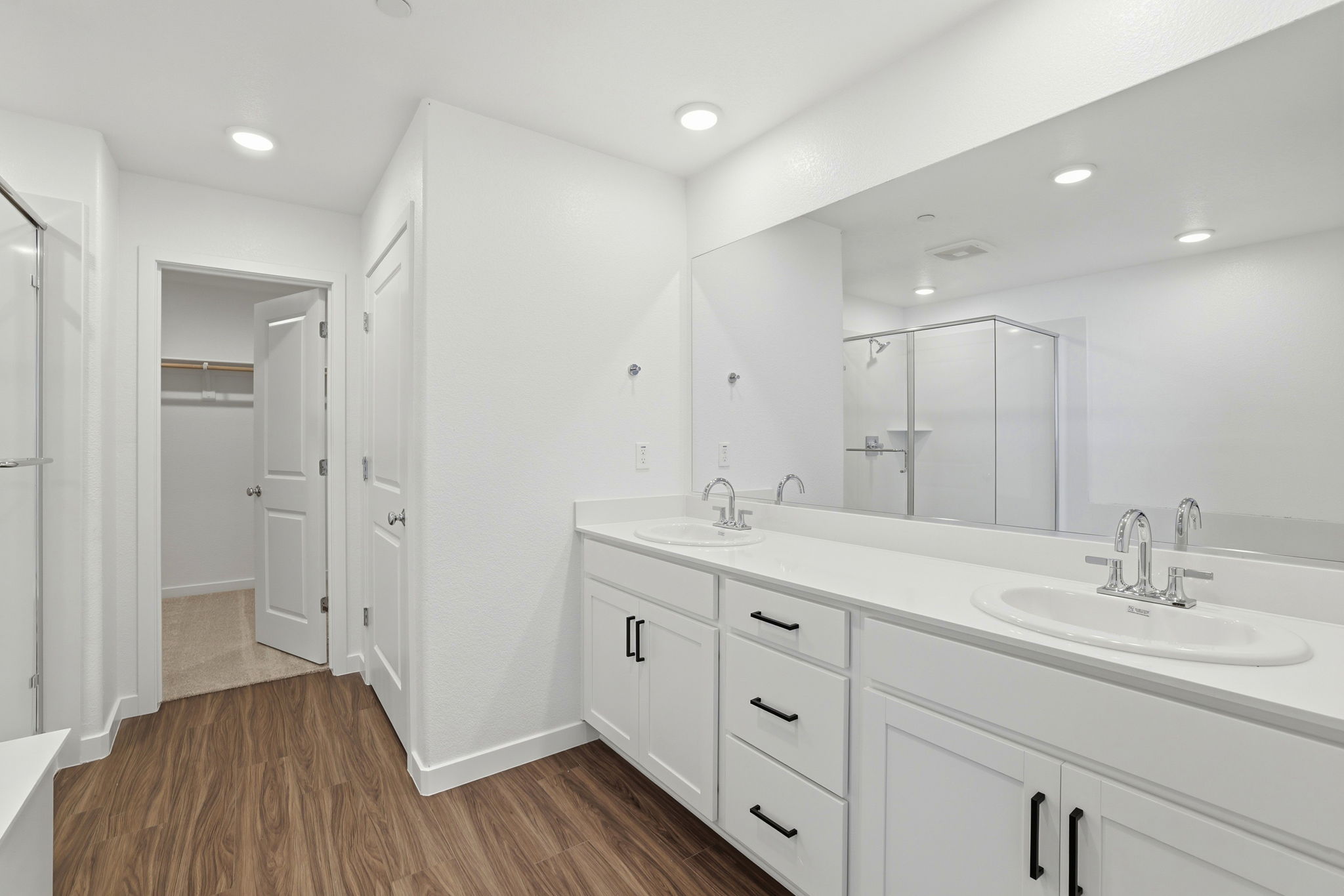 A bathroom with white cabinets.