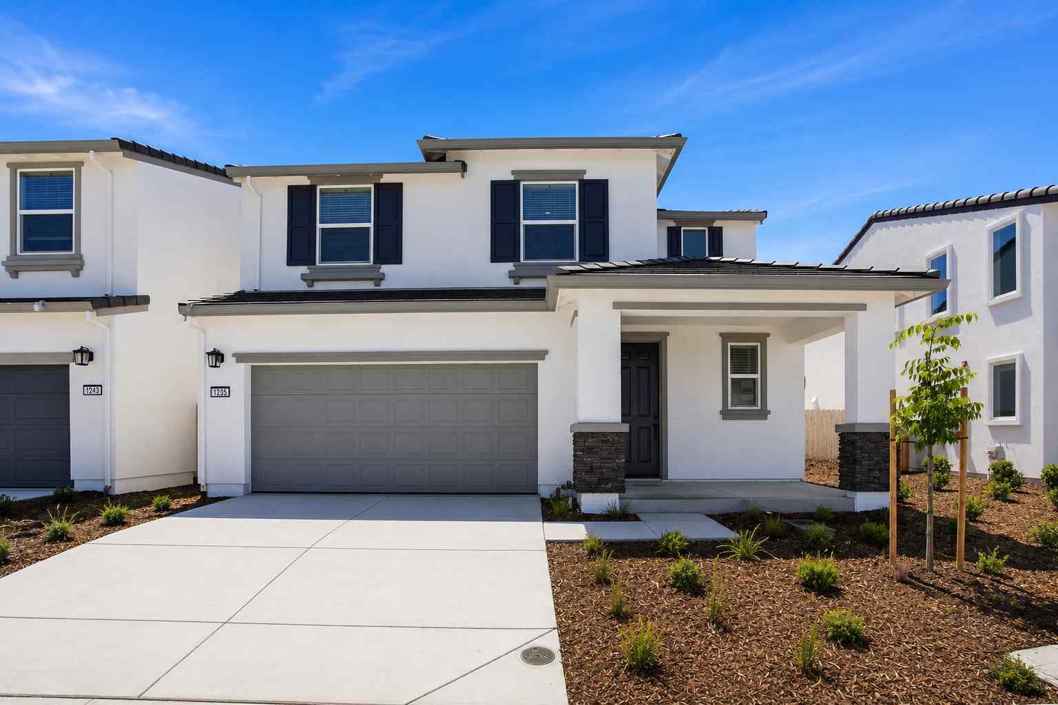 A white house with a garage.