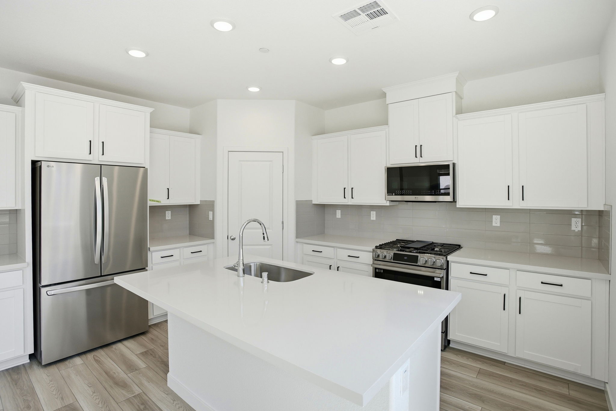 A kitchen with white cabinets.