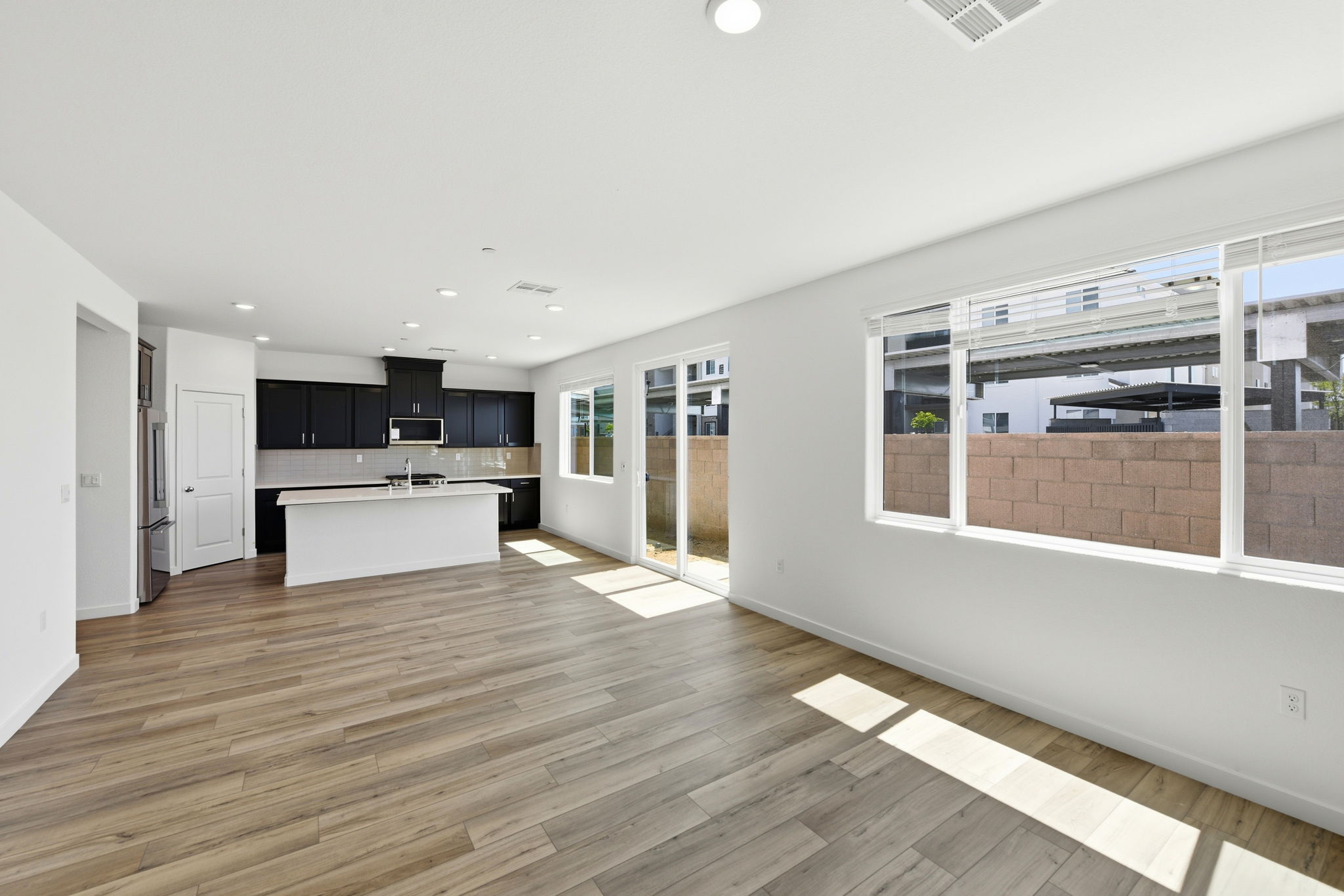 A large empty room with a large kitchen and a large window.