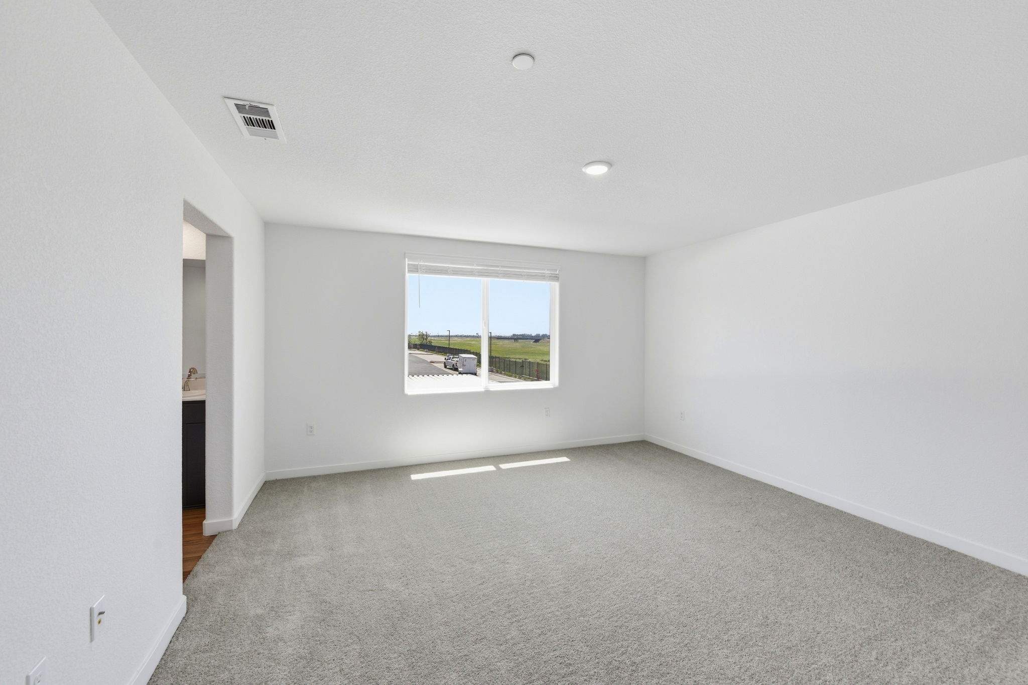 A room with a window and a carpet.