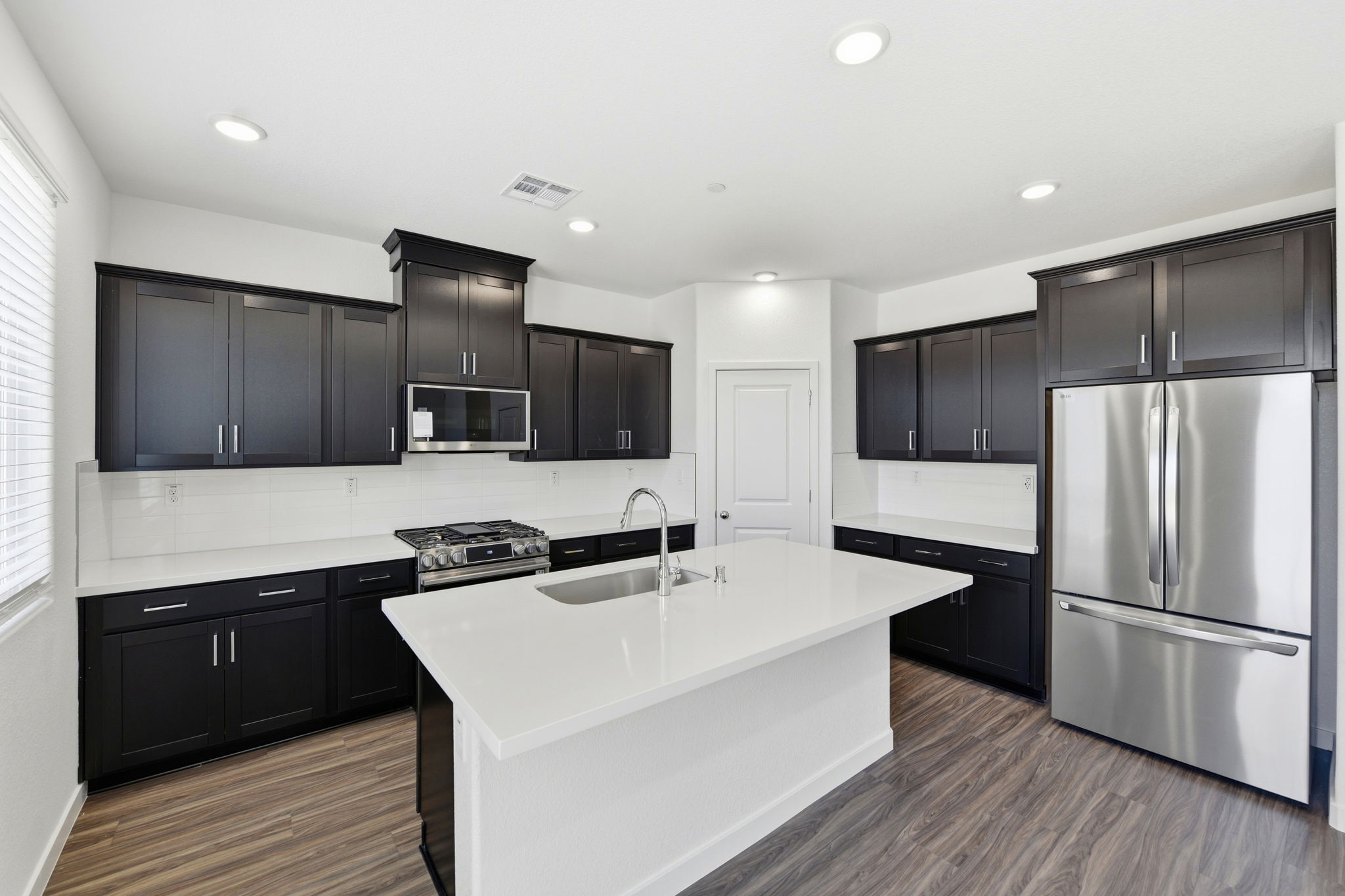 A kitchen with black cabinets.