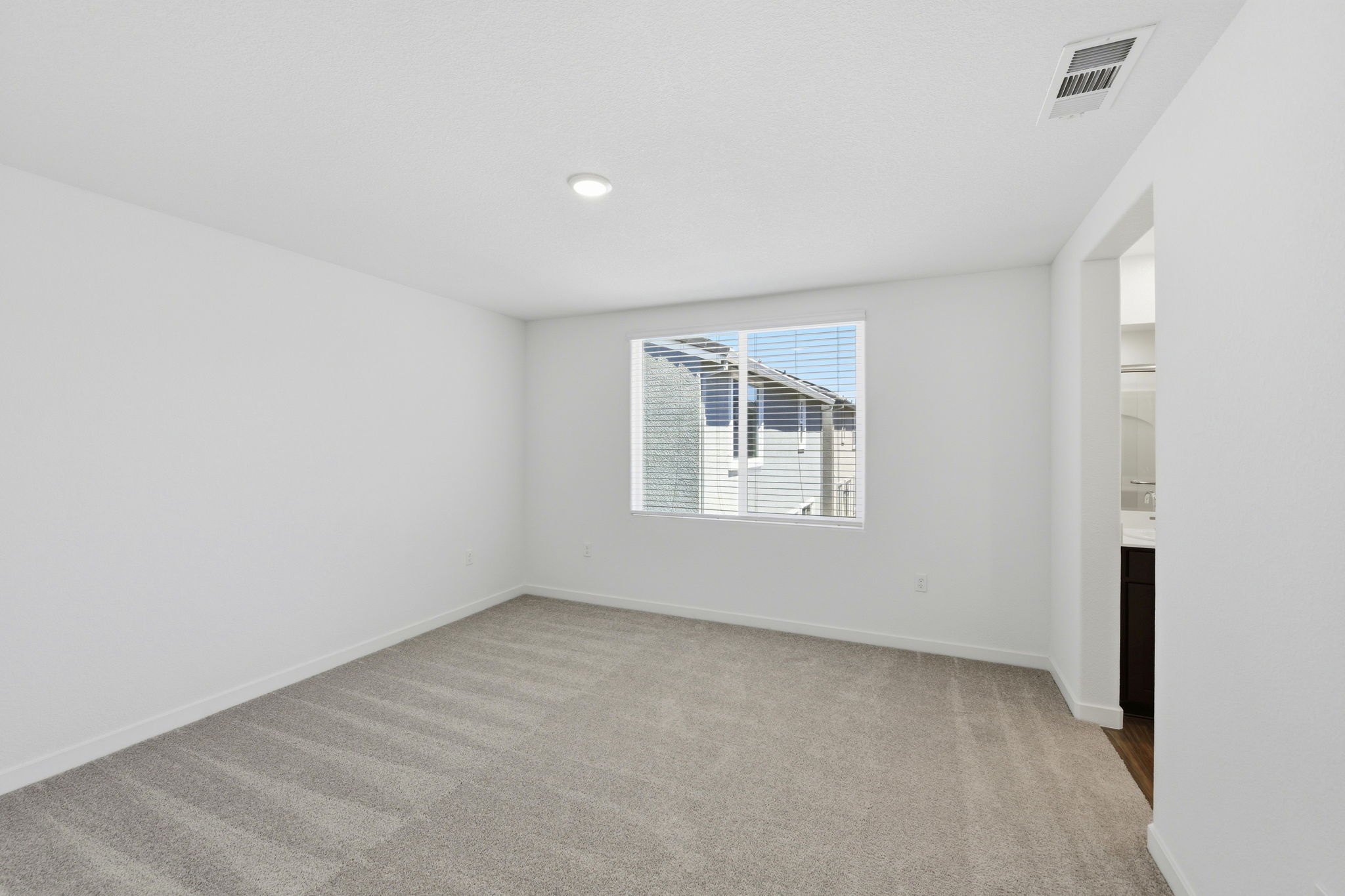 A room with a window and a carpet.