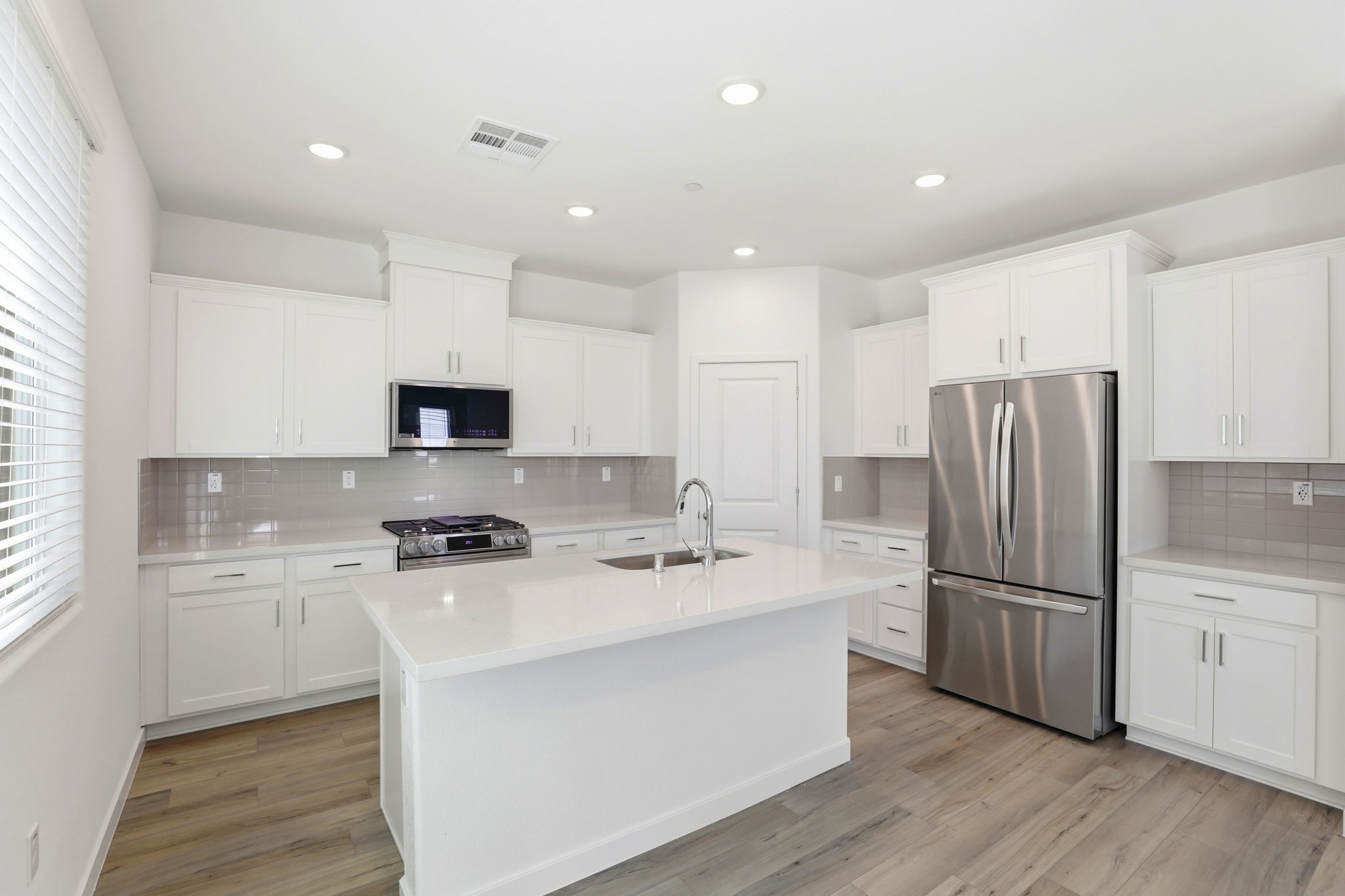 A kitchen with white cabinets.