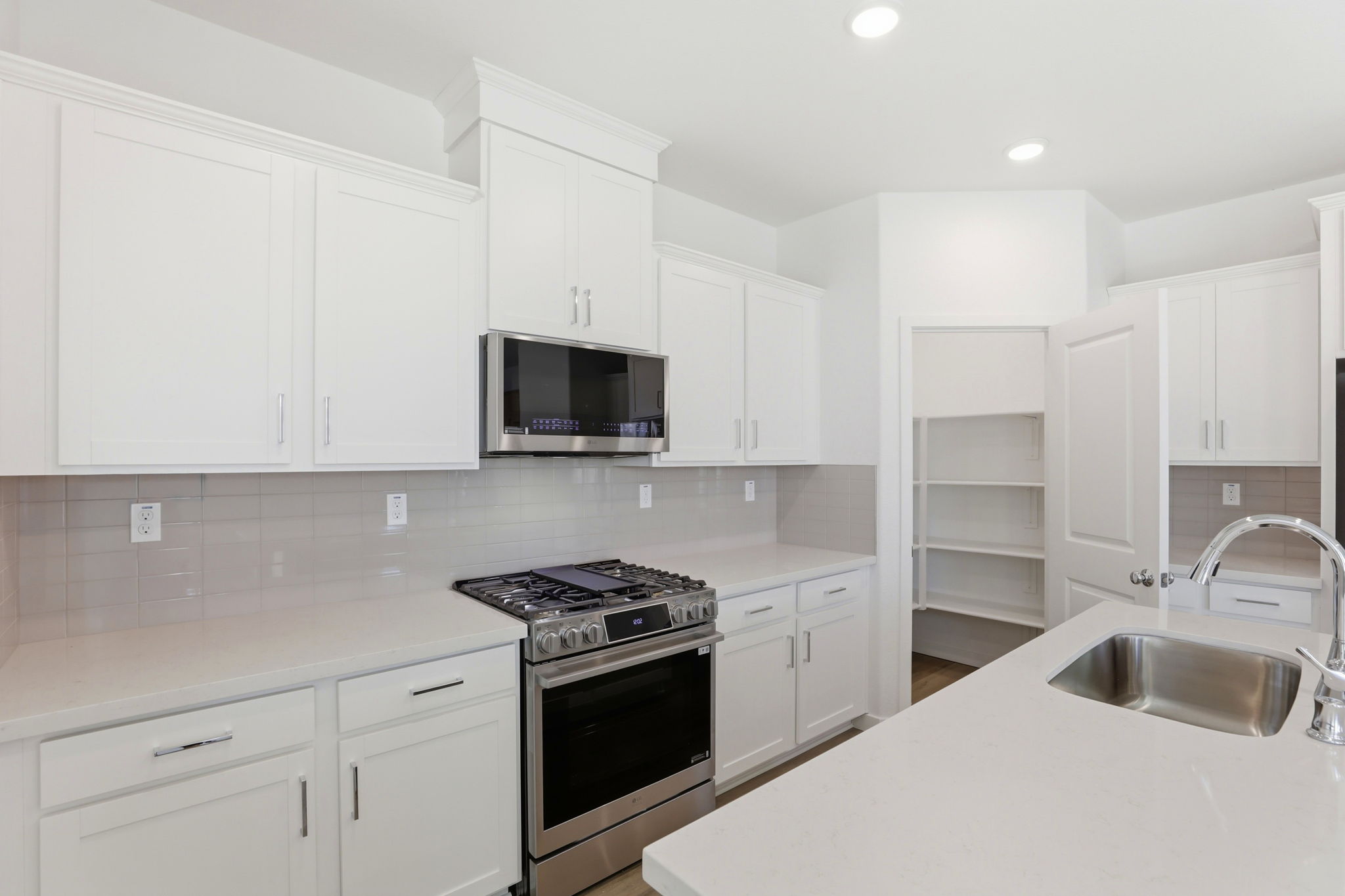 A kitchen with white cabinets.