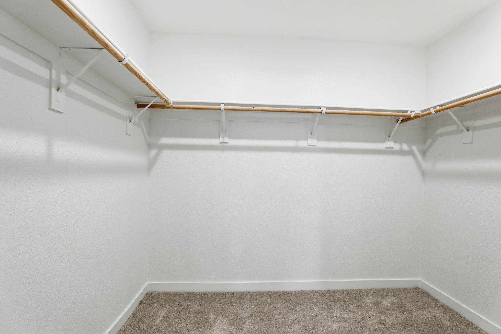 A white wall with a metal bar.