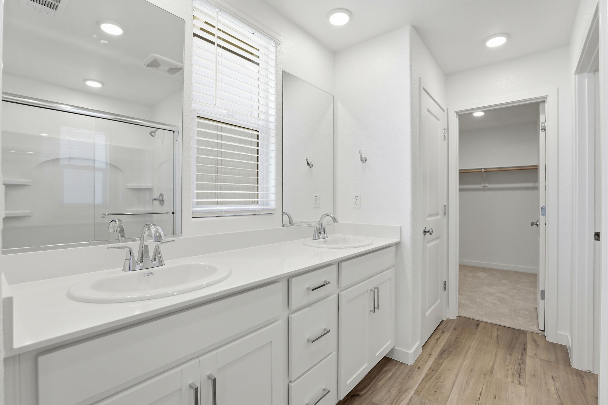 A bathroom with white cabinets.