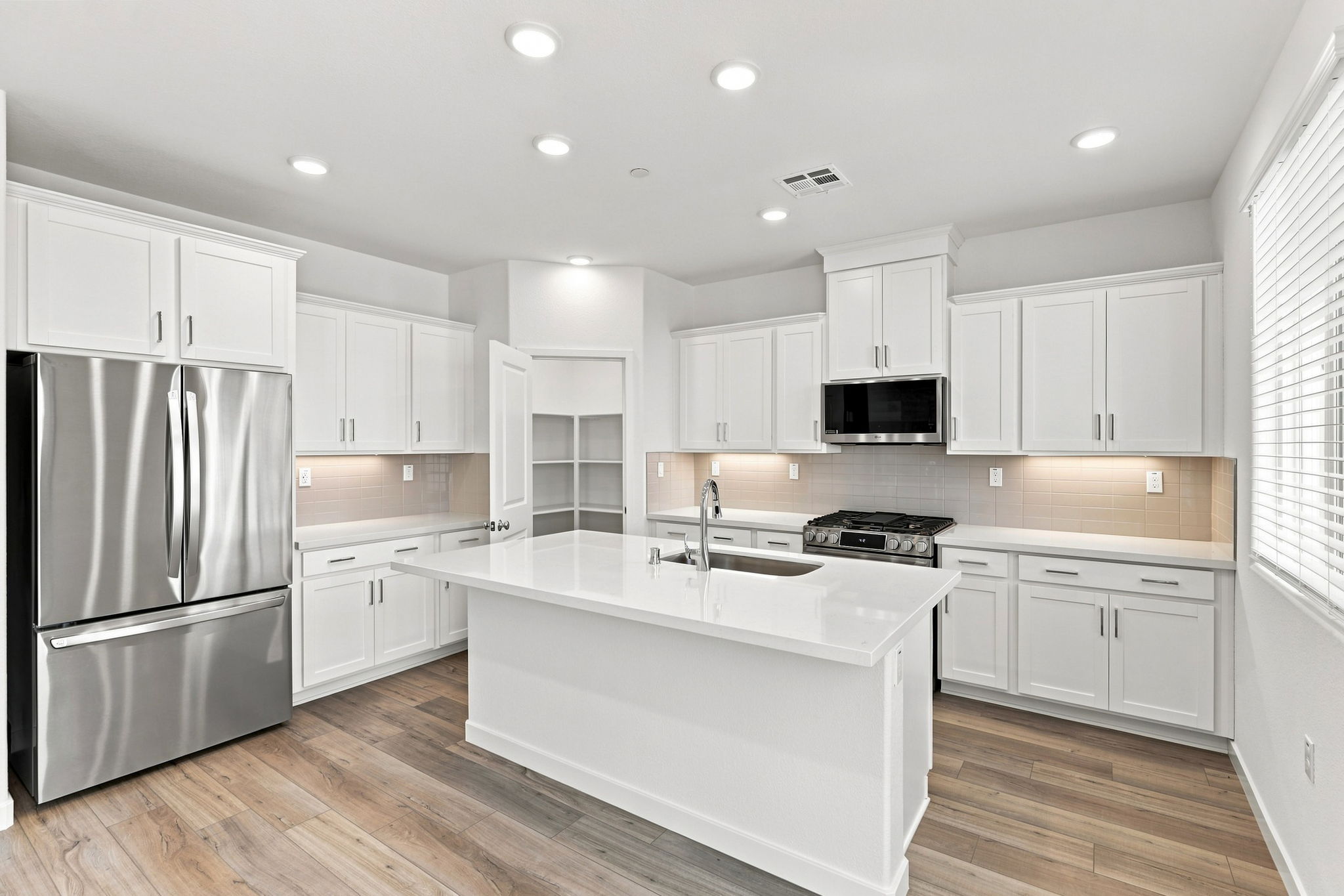 A kitchen with white cabinets.
