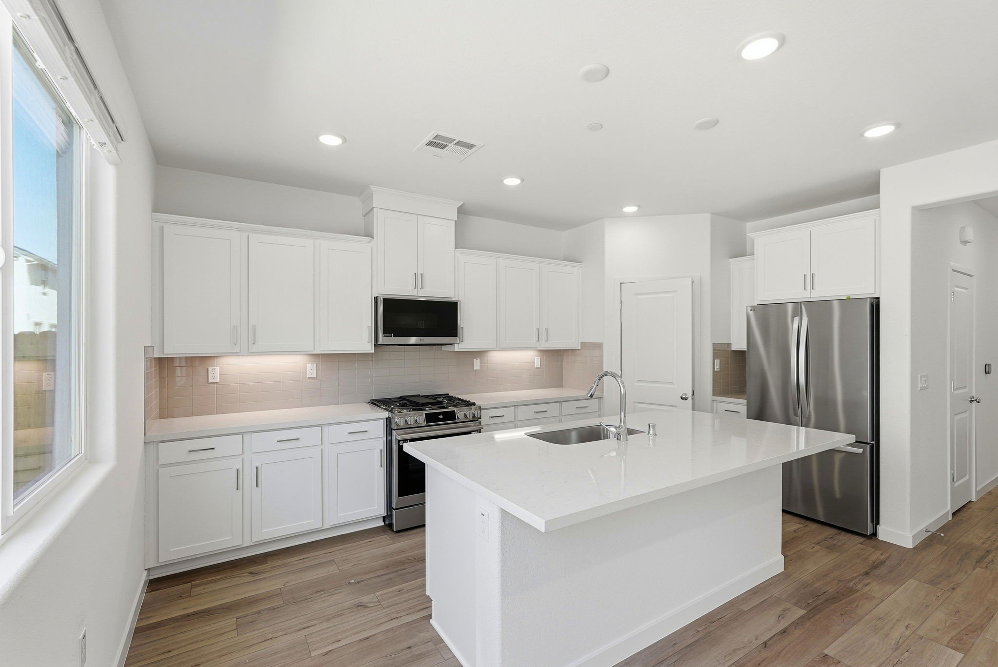 A kitchen with white cabinets.