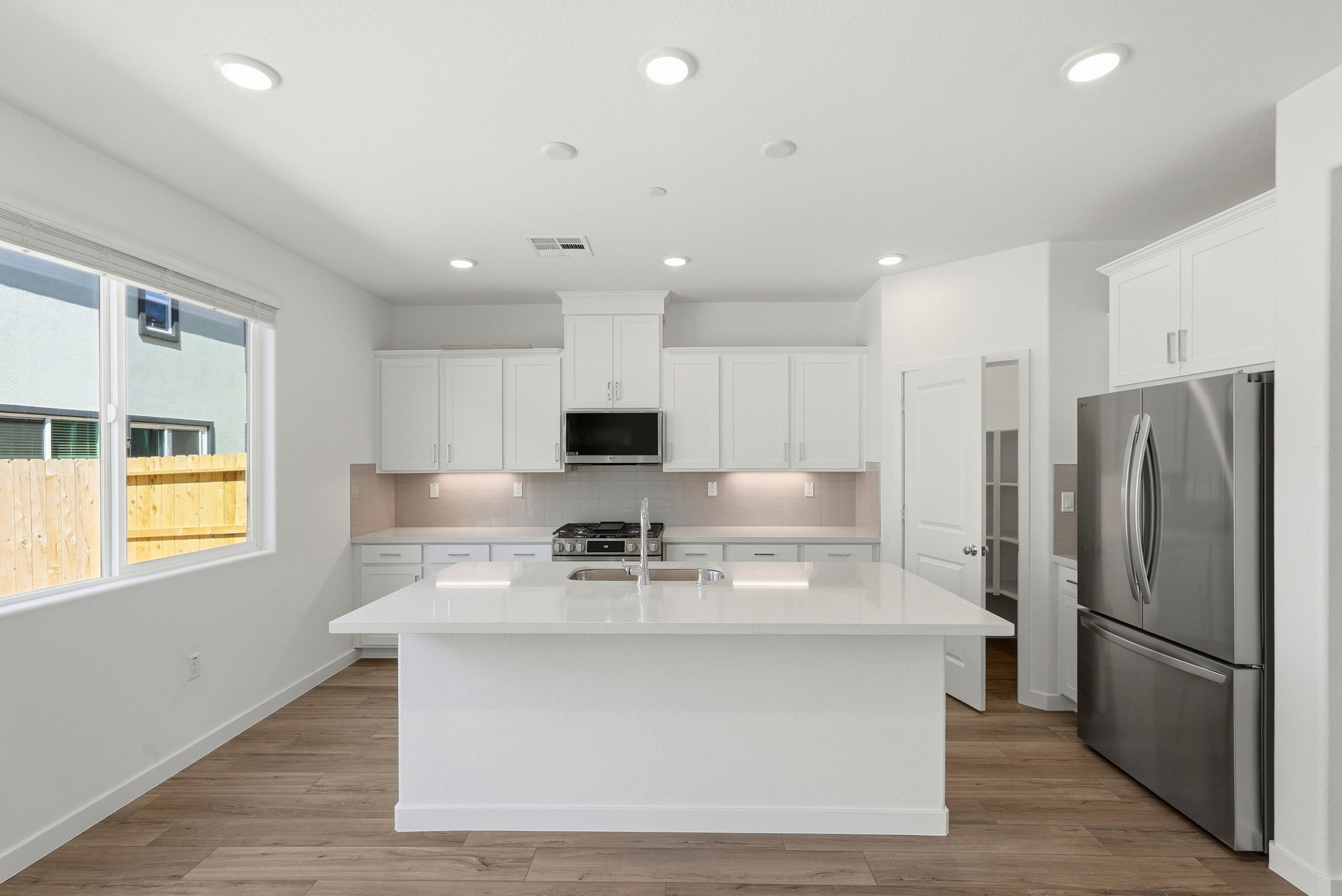 A kitchen with white cabinets.