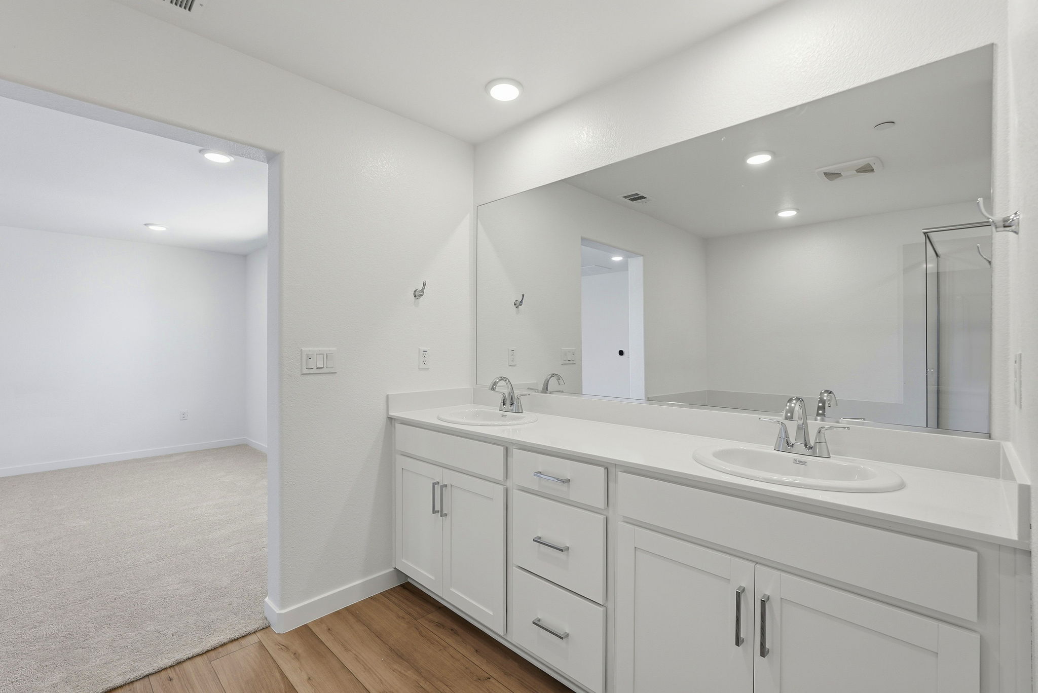A bathroom with white cabinets.