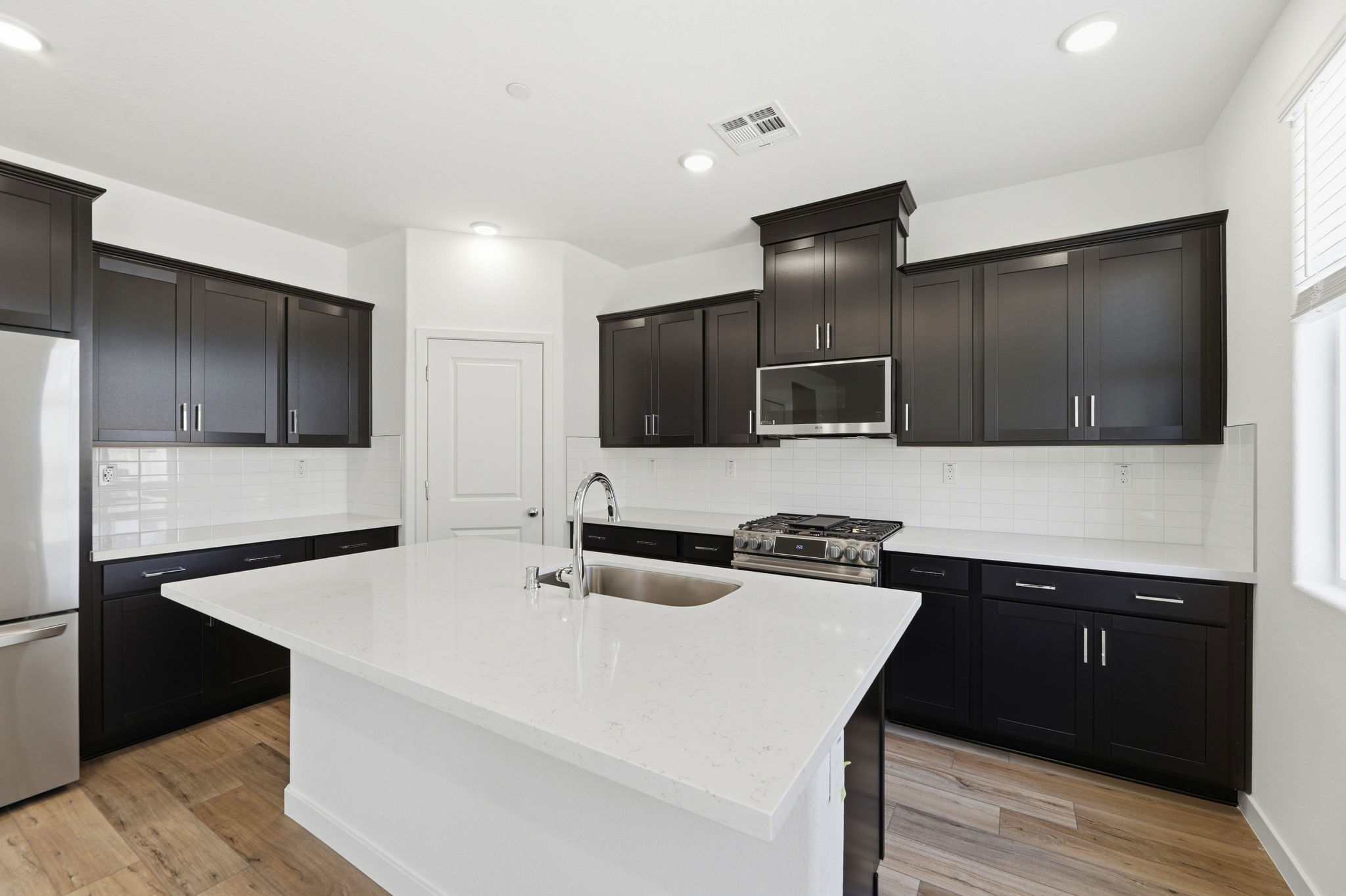 A kitchen with black cabinets.