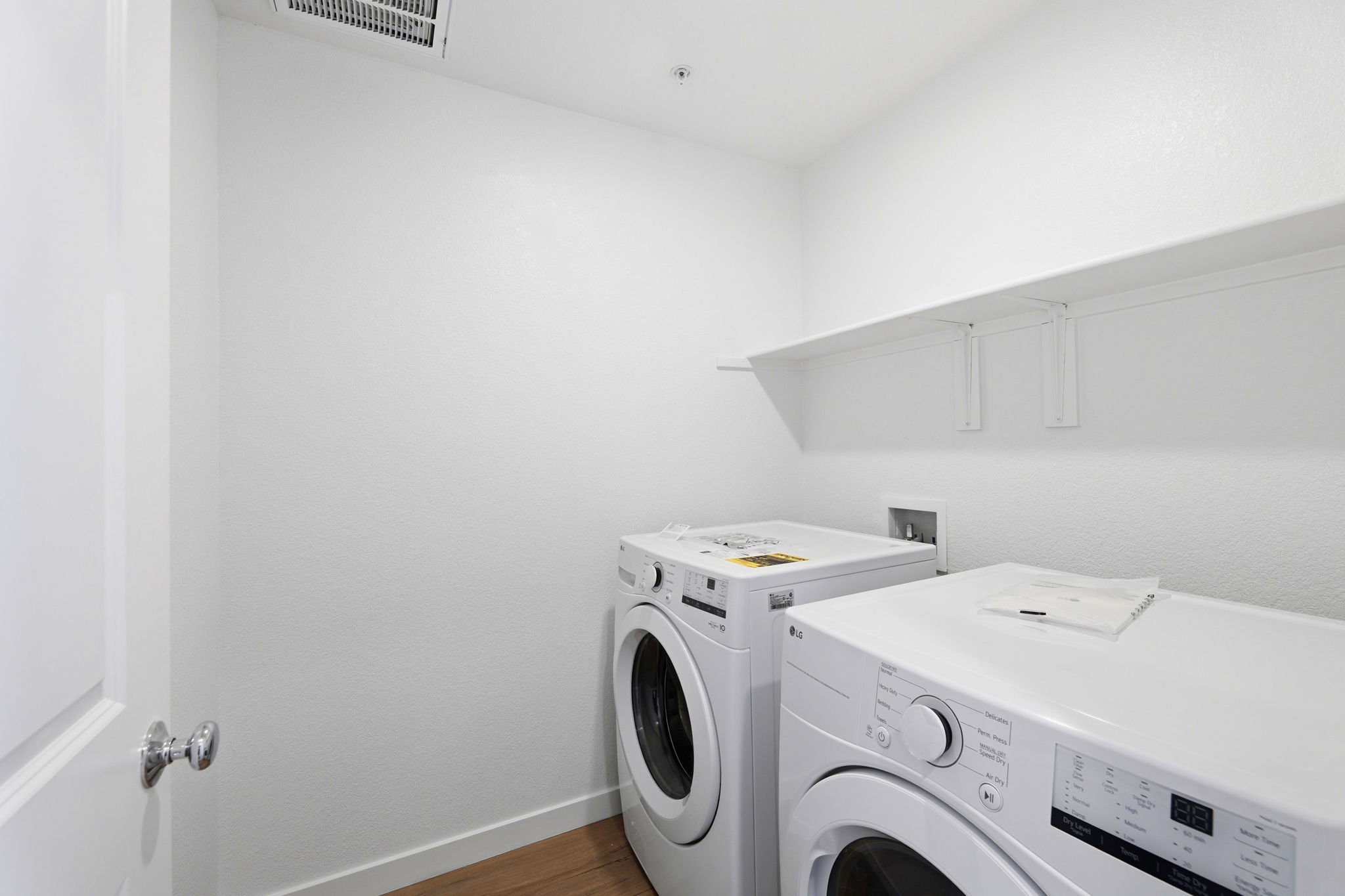 A white laundry room with a washer and dryer.