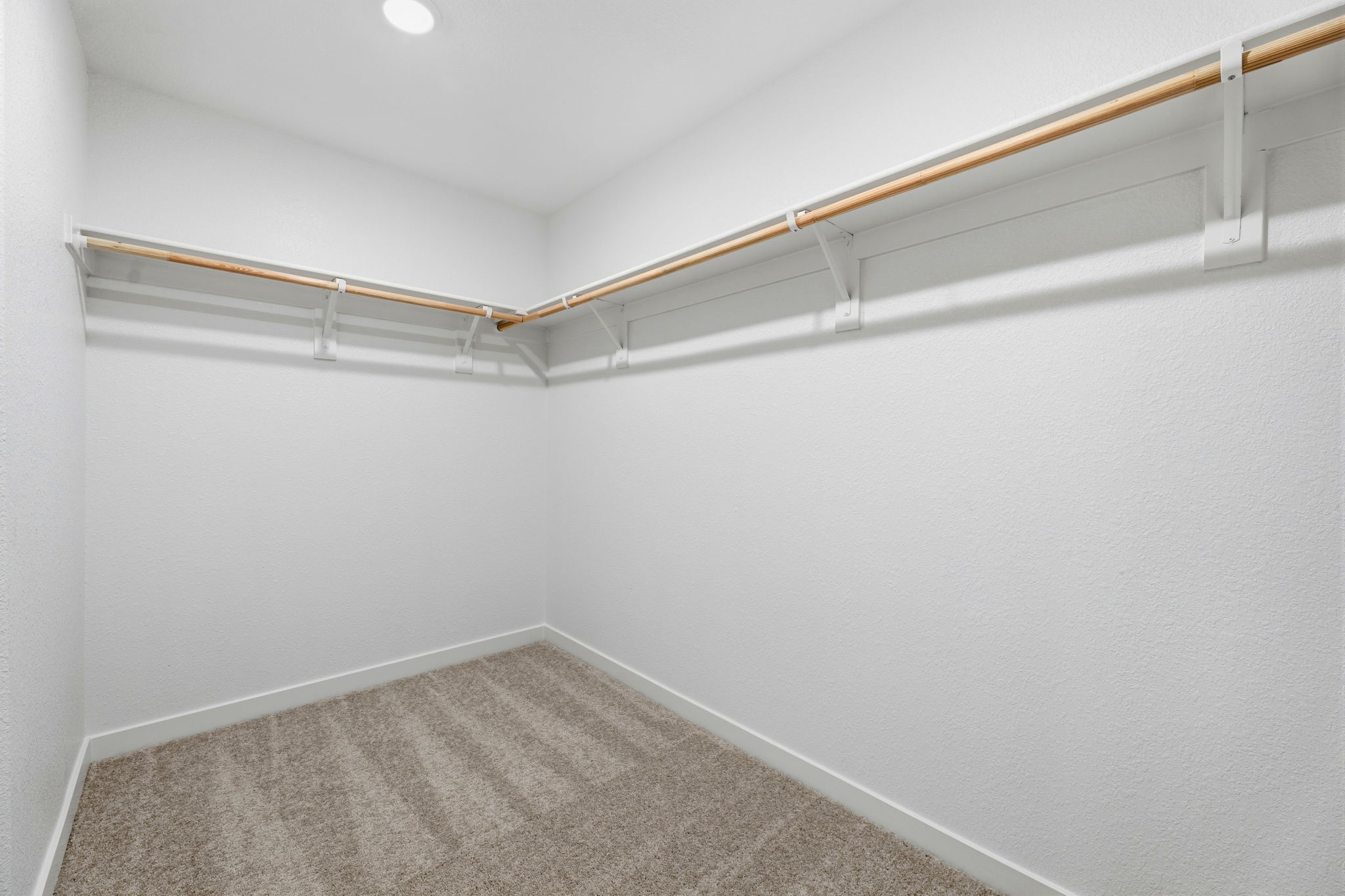 A white room with a carpet and a white wall.